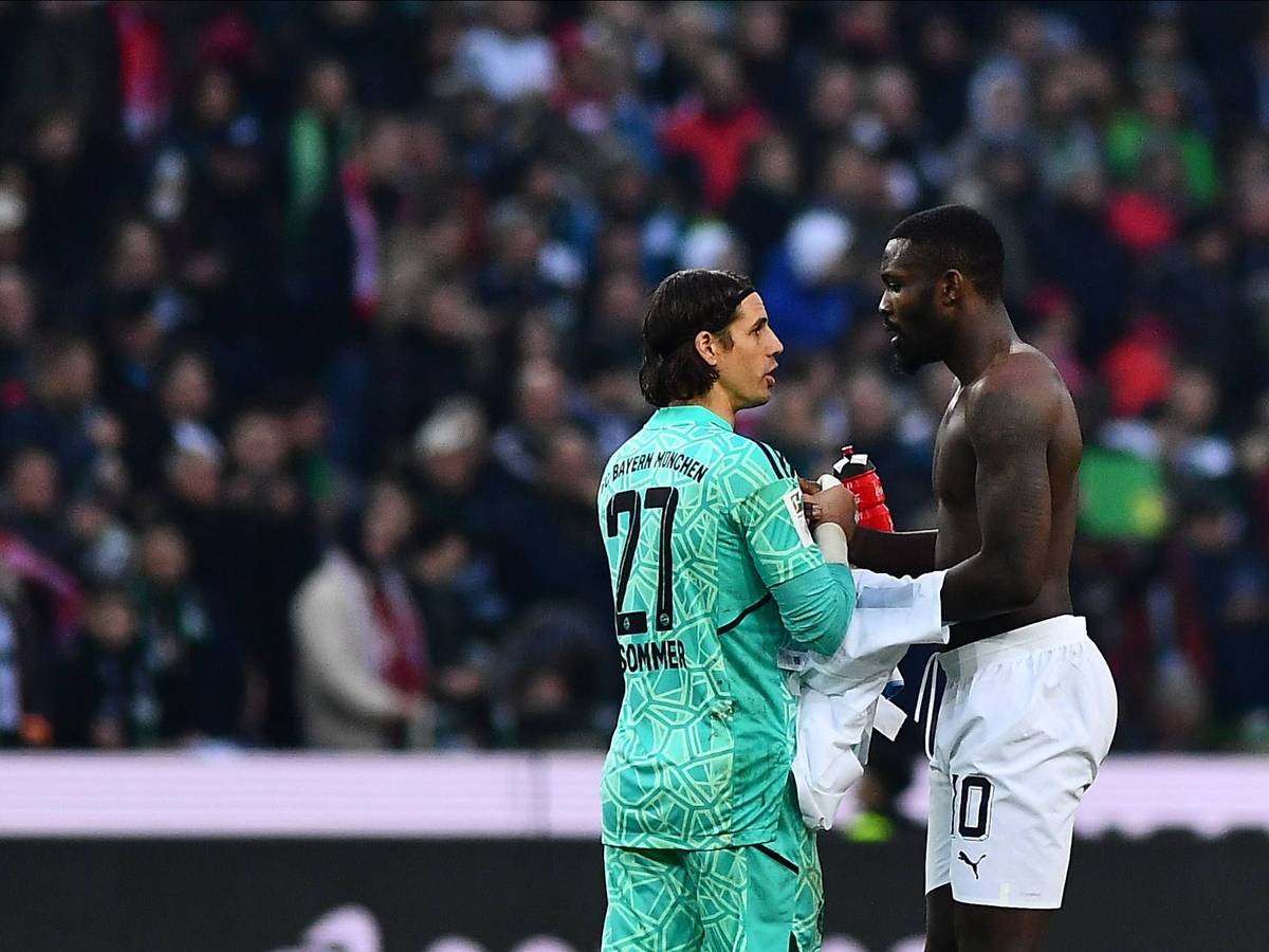 Ex-Gladbach-Torwart Yann Sommer (l.) klatscht sich nach der Bundesliga-Niederlage seines neuen Klubs Bayern München mit Borussia-Stürmer Marcus Thuram (r.) ab. Thuram hat einen nackten Oberkörper und möchte das Trikot mit Sommer tauschen.