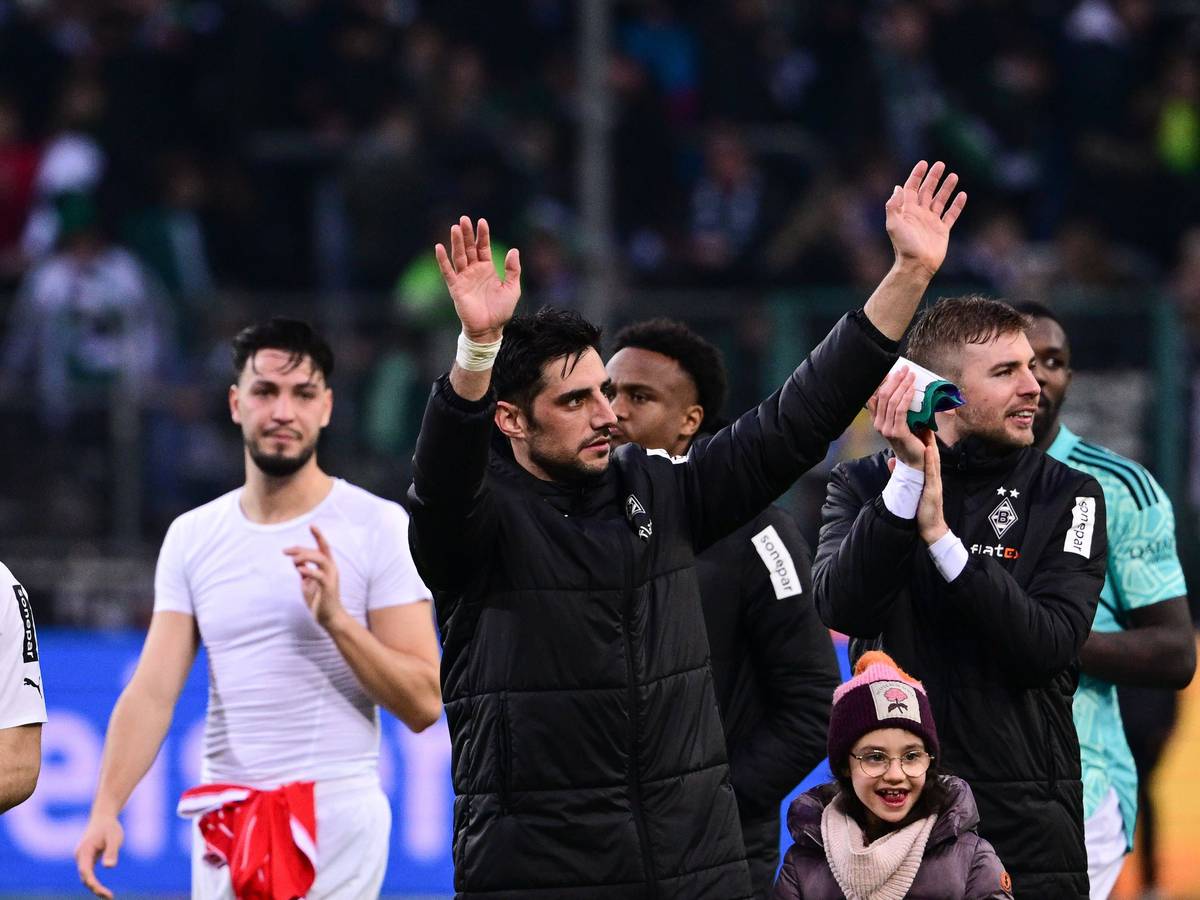 Lars Stindl, Kapitän von Borussia Mönchengladbach, reißt beide Arme in die Luft, um die Gladbach-Fan auf der Tribüne nach dem Sieg gegen den FC Bayern München am 18. Februar 2023 zu grüßen. Um ihn herum stehen die Mitspieler Ramy Bensebaini, Nathan Ngoumou, Christoph Kramer und Marcus Thuram (v.l.n.r).