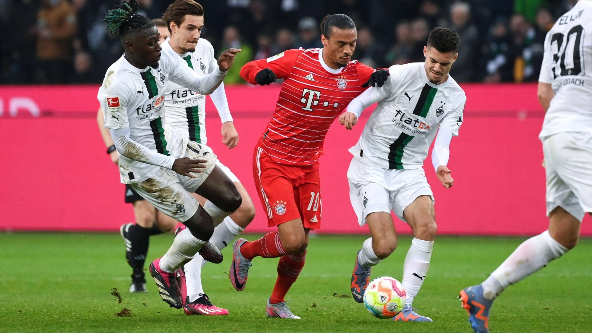 Manu Koné, Florian Neuhaus und Julian Weigl (v. l. n. r.) am 18. Februar 2023 im gemeinsamen Zweikampf mit Leroy Sané vom FC Bayern München.