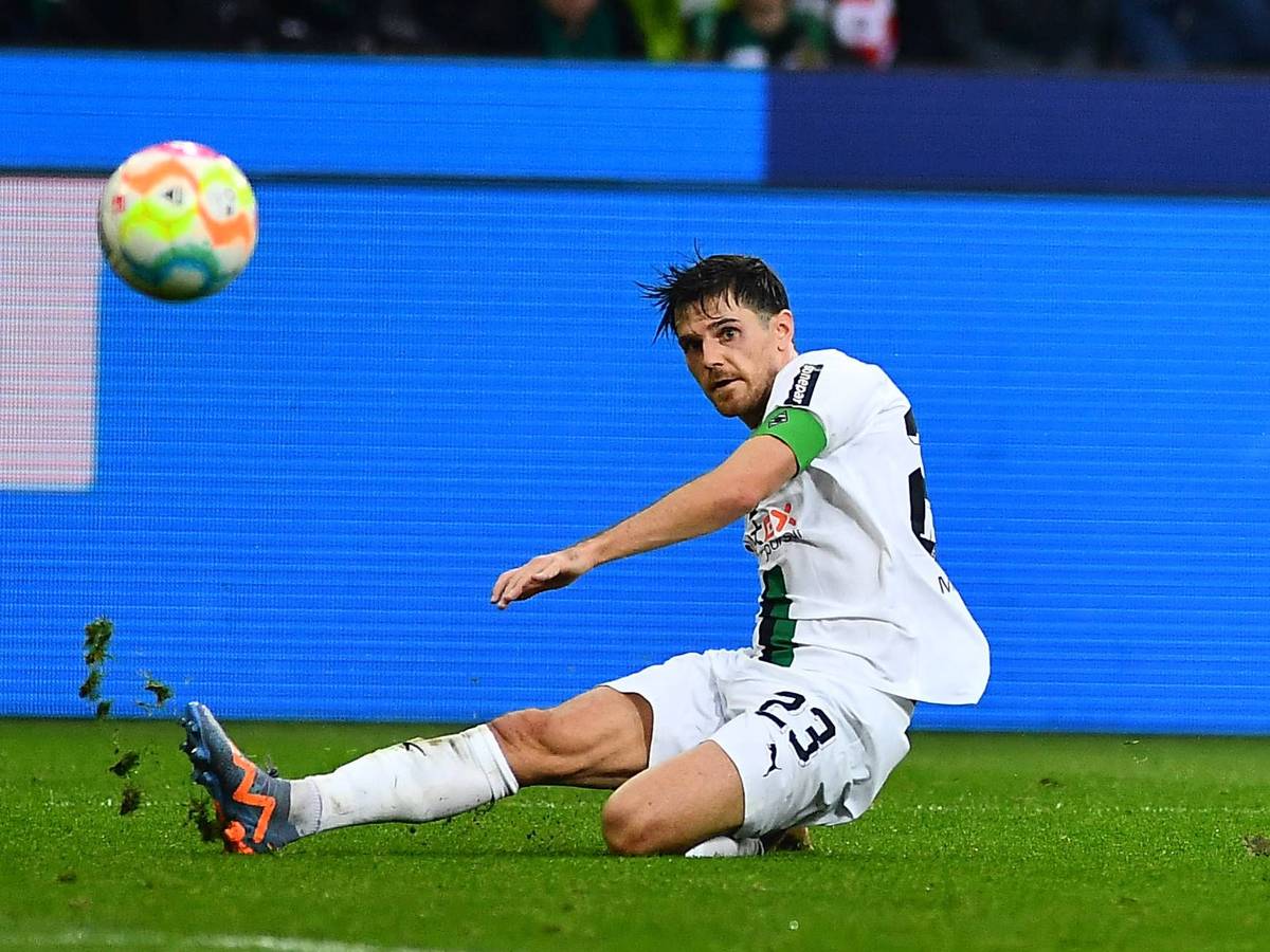Jonas Hofmann trägt im Bundesliga-Spiel von Borussia Mönchengladbach gegen den FC Bayern München am 18. Februar 2023 die Gladbach-Kapitänsbinde. Der Borussia-Spieler grätscht auf dem Rasen im Borussia-Park und blickt auf den fliegenden Ball.