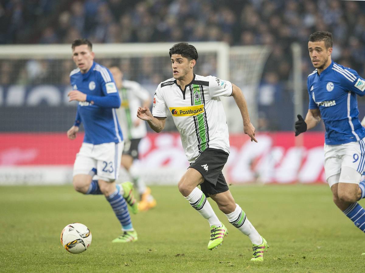 Mo Dahoud (M.) im Trikot von Borussia Mönchengladbach während des Bundesliga-Duells am 18. März 2016 bei Schalke 04. Aktuell steht der Mittelfeldspieler bei Borussia Dortmund unter Vertrag. Dahoud führt den Ball am Fuß. Er wird von einem Gegenspieler verfolgt.