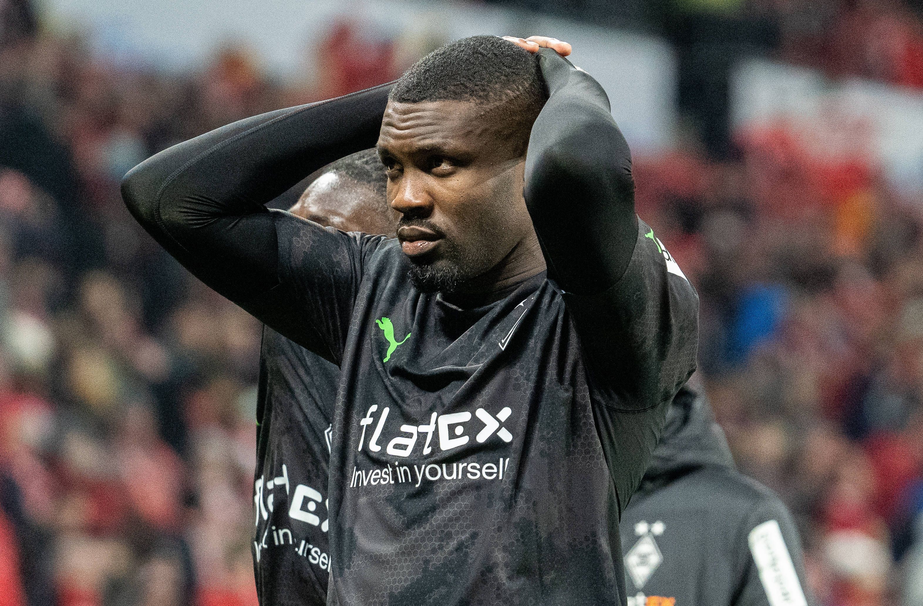 Marcus Thuram steht vor der Auswärtskurve mit den Fans von Borussia Mönchengladbach und fasst sich nach der Bundesliga-Niederlage beim FSV Mainz 05 am 24. Februar 2023 mit beiden Händen an den Kopf.