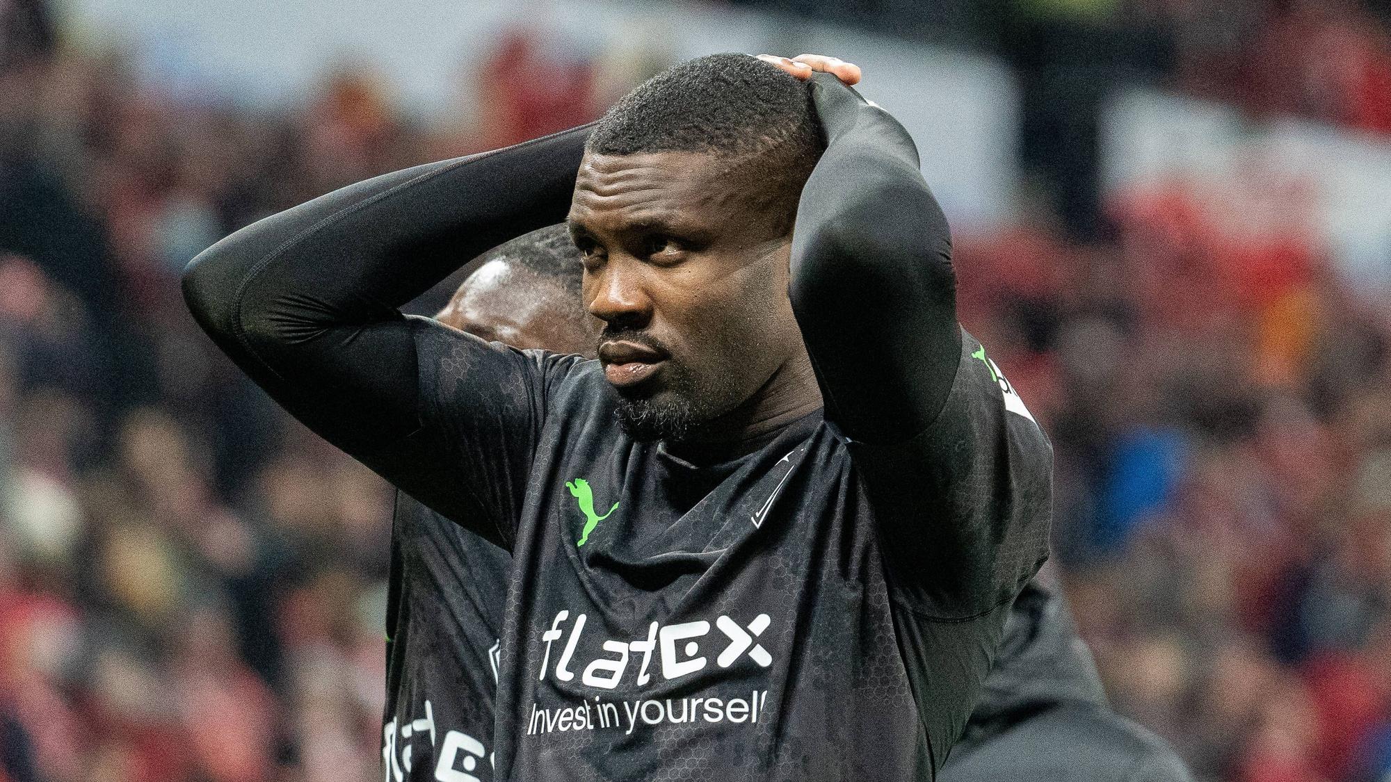 Marcus Thuram steht vor der Auswärtskurve mit den Fans von Borussia Mönchengladbach und fasst sich nach der Bundesliga-Niederlage beim FSV Mainz 05 am 24. Februar 2023 mit beiden Händen an den Kopf.