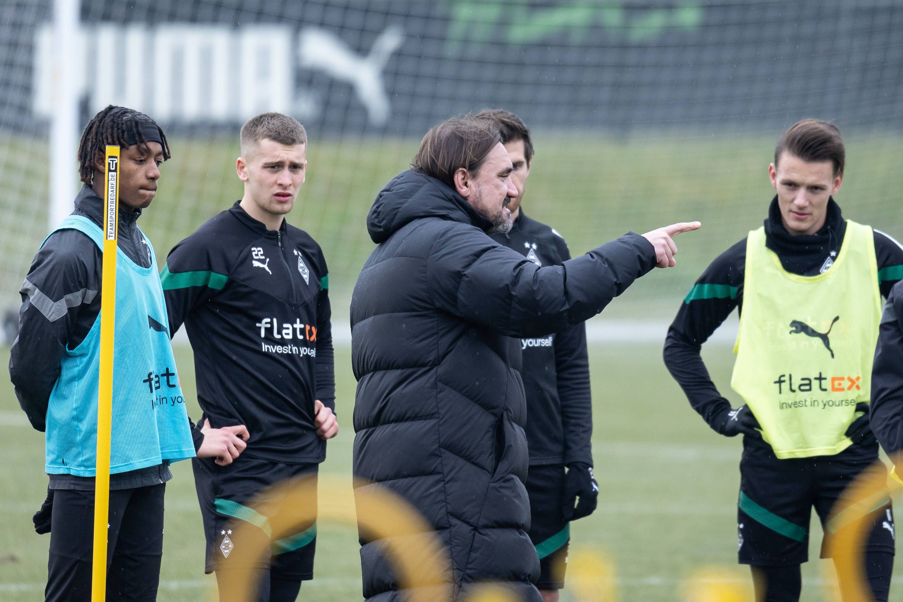 Trainer Daniel Farke gibt den Spielern von Borussia im Training Anweisungen, hier am 16. Februar 2023. Yvandro Borges Sanches, Oscar Fraulo, Jonas Hofmann und Hannes Wolf (v. l. n. r.) hören und sehen zu, während Farke mit seinem Finger etwas anzeigt.