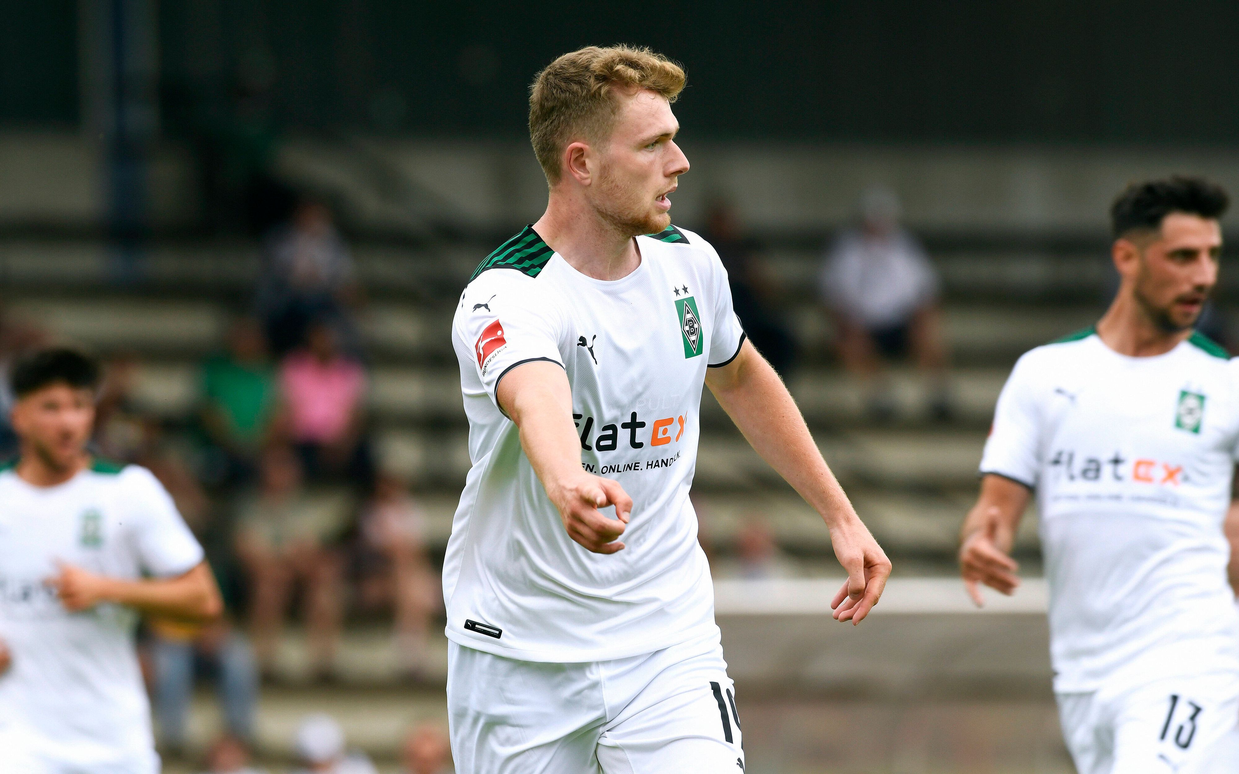 Steffen Meuer spielt am 10. Juli 2021 im Trikot von Borussia Mönchengladbach bei einem Testspiel der Profis gegen Viktoria Köln. Das Foto zeigt Meuer im weißen Gladbach-Heimtrikot, er macht eine Zeige-Bewegung mit dem rechten Arm.