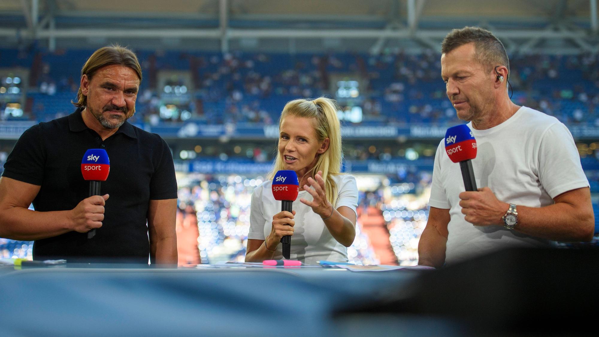 Daniel Farke (l.) und Lothar Matthäus (r.) hören vor dem Bundesliga-Spiel von Borussia Mönchengladbach beim FC Schalke 04 am 13. August 2022 der Analyse von Julia Simic bei einer Sky-Übertragung zu. Alle halten ein Mikrofon des Pay-TV-Senders in der Hand.