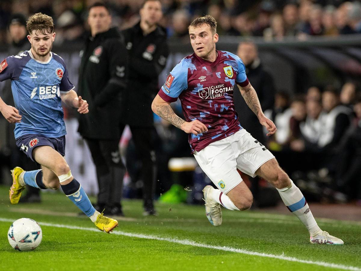 Gladbach hat Jordan Beyer (r.) an England-Klub FC Burnley verliehen. Auf diesem Foto ist der Verteidiger im Einsatz (1. März 2023) gegen Fleetwood Town zu sehen. Beyer hat den Ball im vollen Lauf im Blick, sein Gegenspieler läuft hinterher.