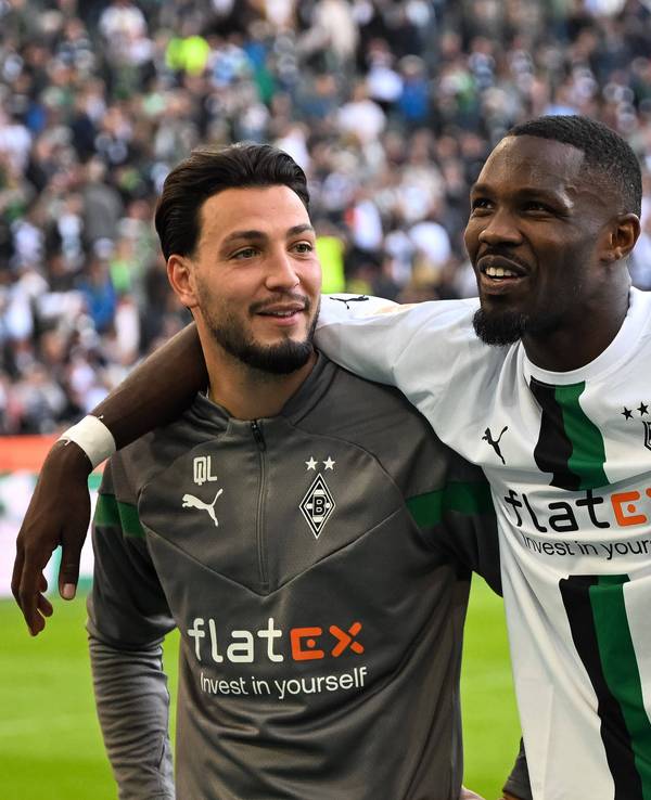 Ramy Bensebaini (l.) und Marcus Thuram (r.) werden Borussia Mönchengladbach aller Voraussicht nach im Sommer ablösefrei verlassen. Das Foto zeigt die beiden am 9. Oktober 2022 gemeinsam mit ihrem Teamkollegen Alassane Plea beim Feiern nach dem gewonnenen Derby gegen Köln mit den Fans.
