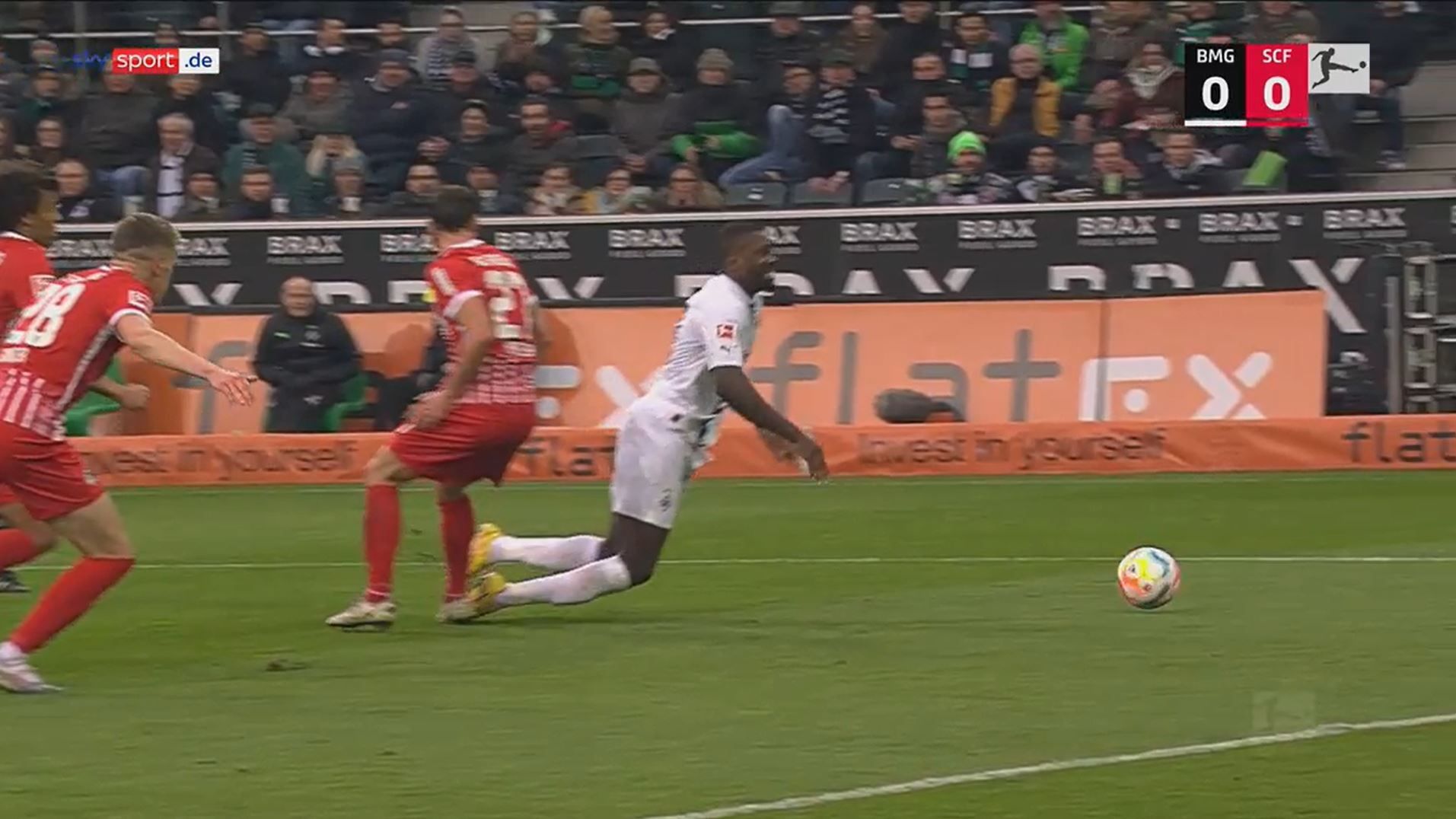 Marcus Thuram geht im Spiel zwischen Borussia Mönchengladbach und dem SC Freiburg zu Boden.