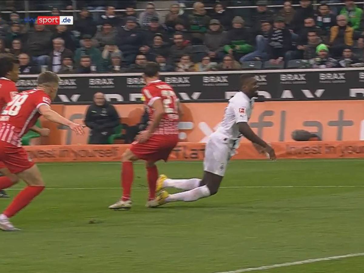 Marcus Thuram geht im Spiel zwischen Borussia Mönchengladbach und dem SC Freiburg zu Boden.