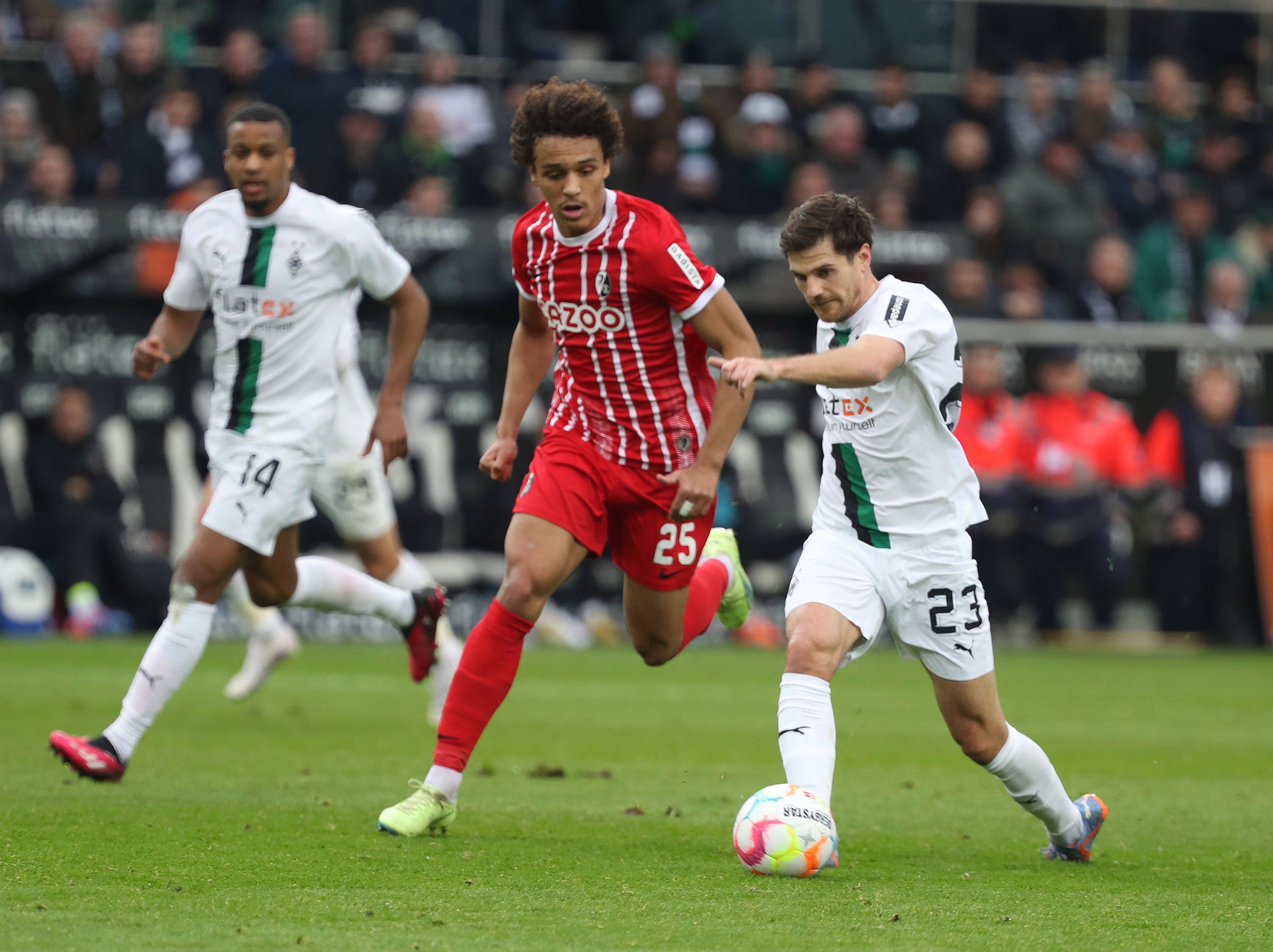 Die Gladbach-Stars Jonas Hofmann (r.) und Alassane Plea (l.) im Laufduell (4. März 2023) mit Kiliann Sildillia vom SC Freiburg im Borussia-Park.