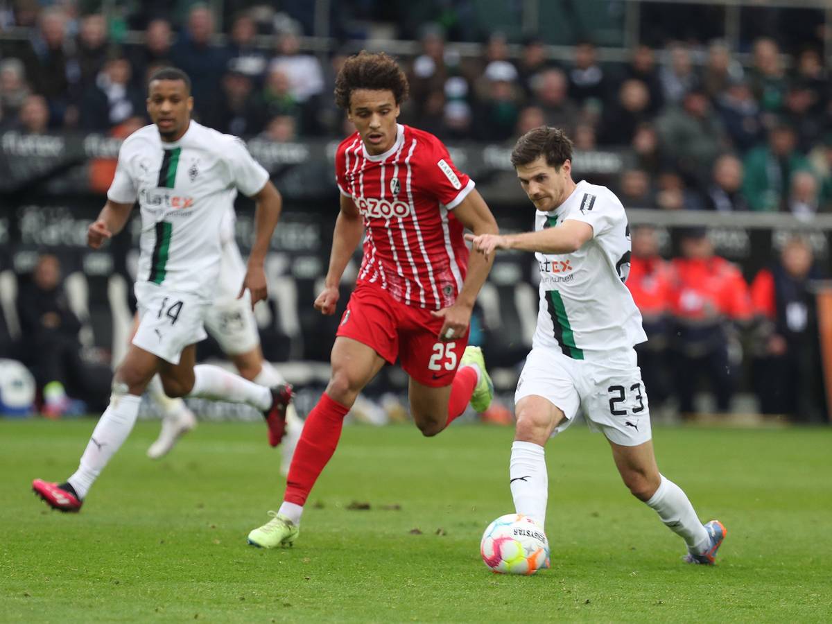 Die Gladbach-Stars Jonas Hofmann (r.) und Alassane Plea (l.) im Laufduell (4. März 2023) mit Kiliann Sildillia vom SC Freiburg im Borussia-Park.