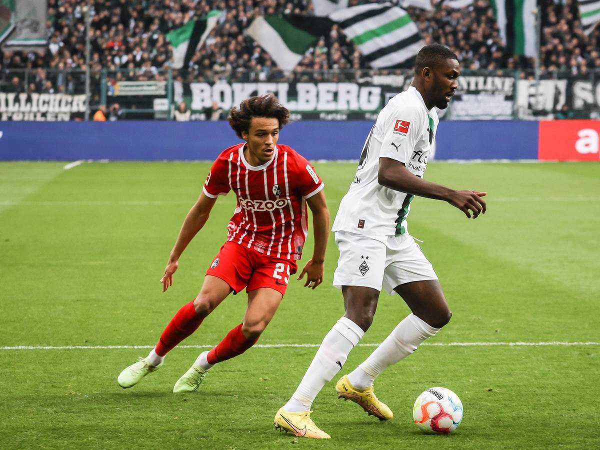 Borussia Mönchengladbach hat am Samstag (4. März 2023) 0:0 gegen den SC Freiburg gespielt. Das Foto zeigt SCF-Spieler Kiliann Sildillia (l.) im Laufduell mit Gladbachs Marcus Thuram (r.).