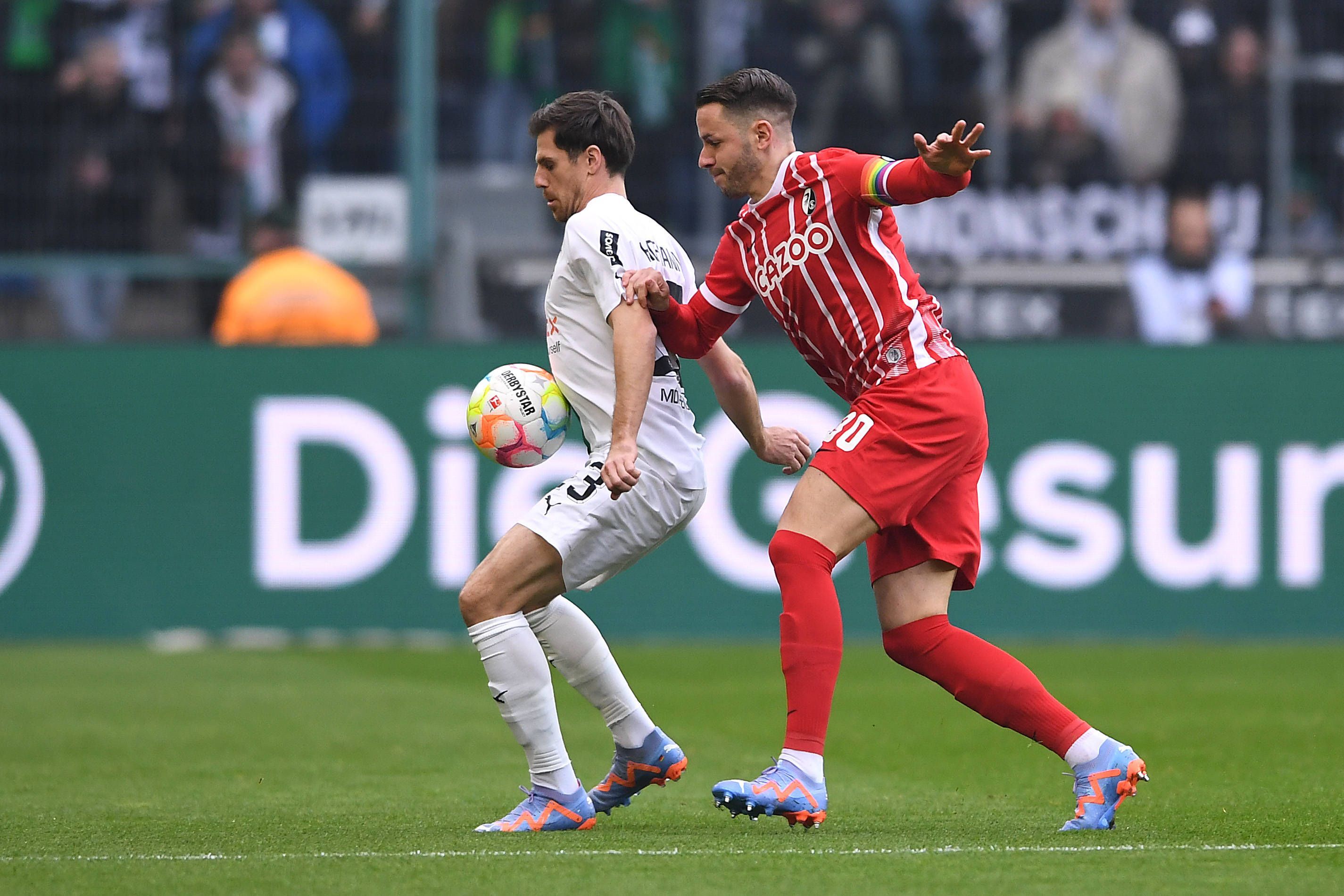 Jonas Hofmann von Borussia Mönchengladbach (l.) am 4. März 2023 im Zweikampf mit Christian Günter vom SC Freiburg.
