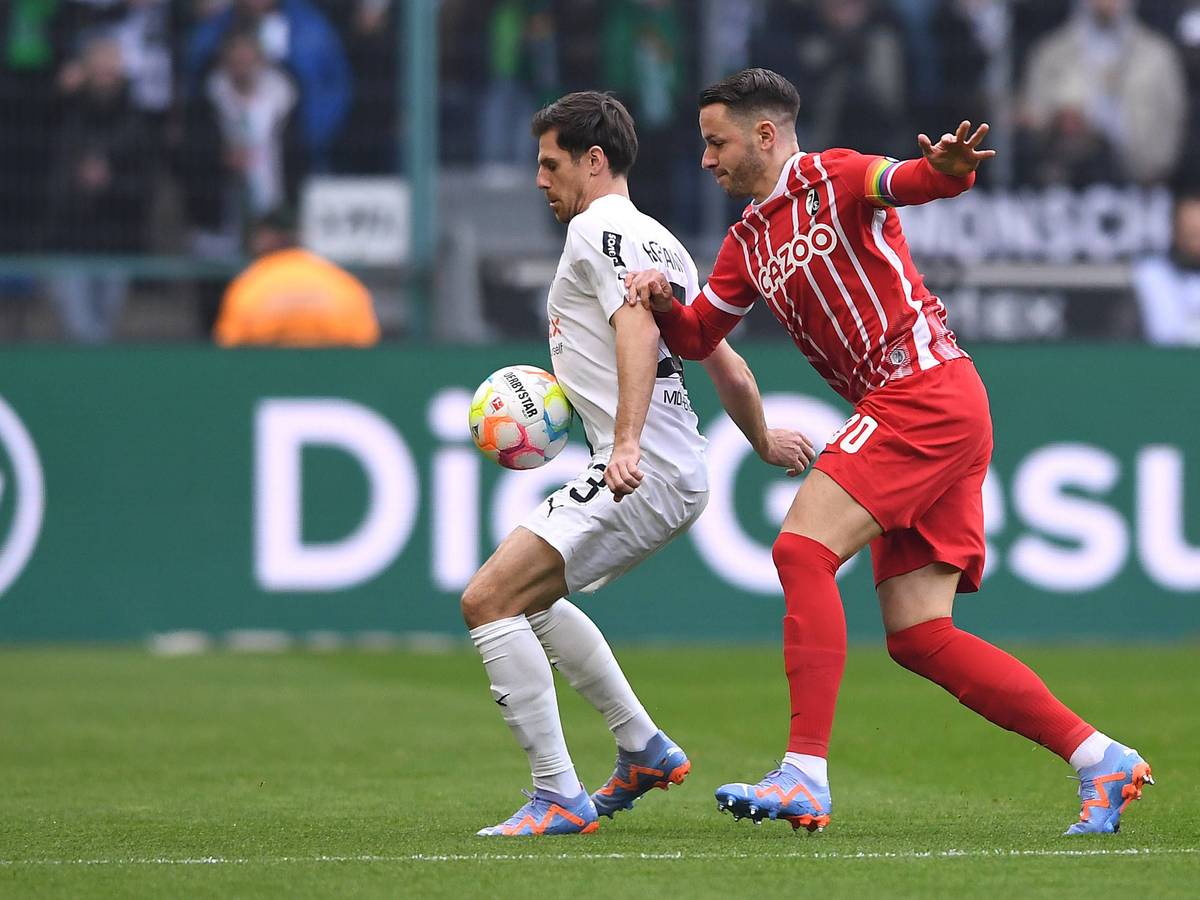 Jonas Hofmann von Borussia Mönchengladbach (l.) am 4. März 2023 im Zweikampf mit Christian Günter vom SC Freiburg.