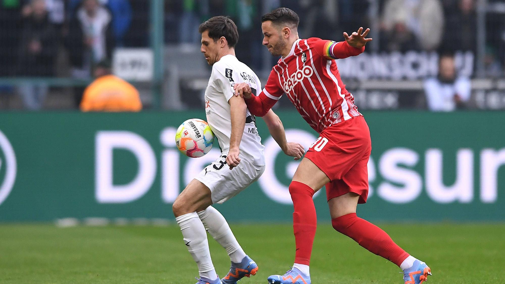 Jonas Hofmann von Borussia Mönchengladbach (l.) am 4. März 2023 im Zweikampf mit Christian Günter vom SC Freiburg.