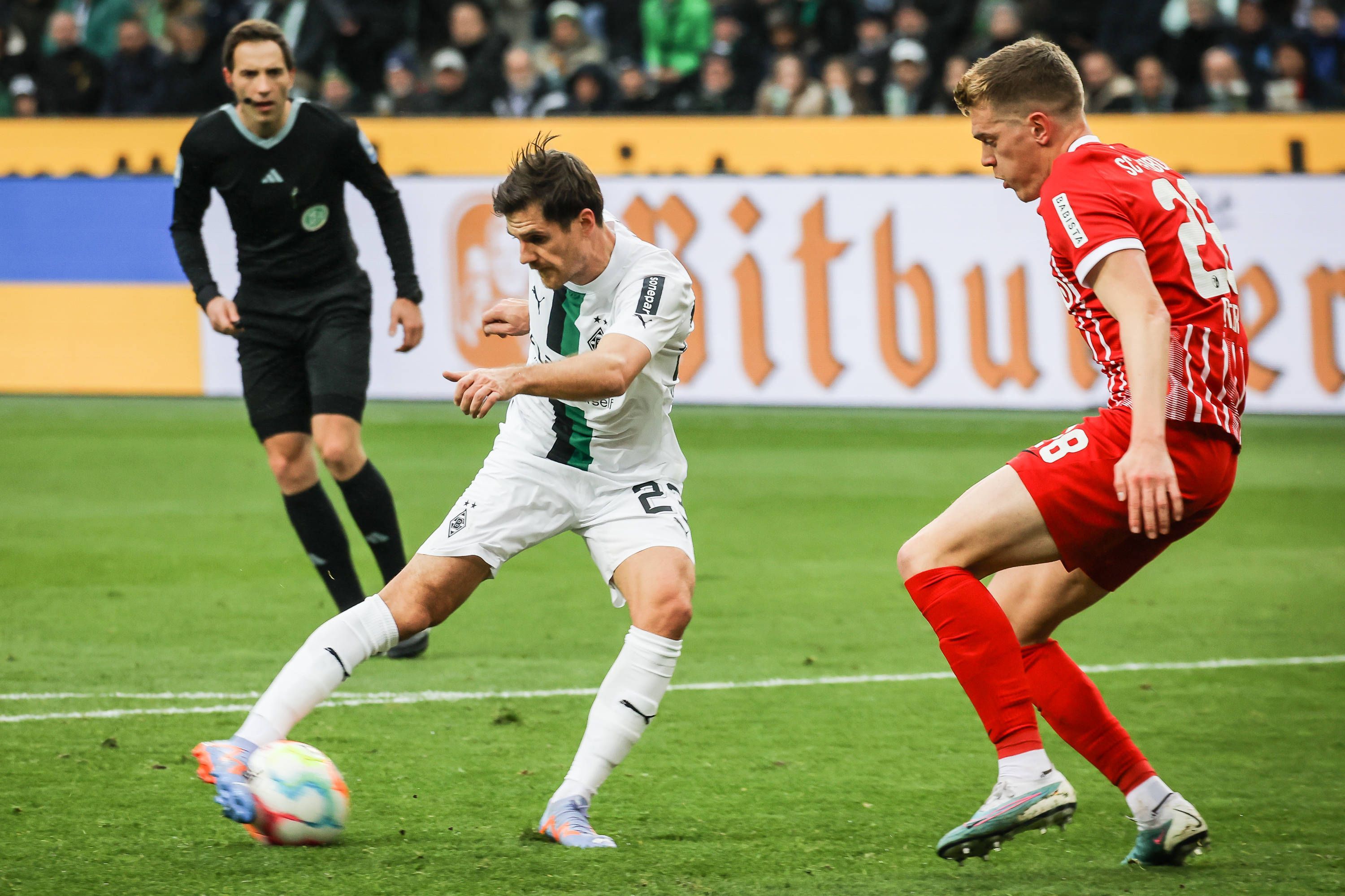 Gladbach-Star Jonas Hofmann (l.) im Zweikampf mit Matthias Ginter (r.) vom SC Freiburg während der Bundesliga-Partie am Samstag (4. März 2023) im Borussia-Park. Hofmann schießt mit rechts.