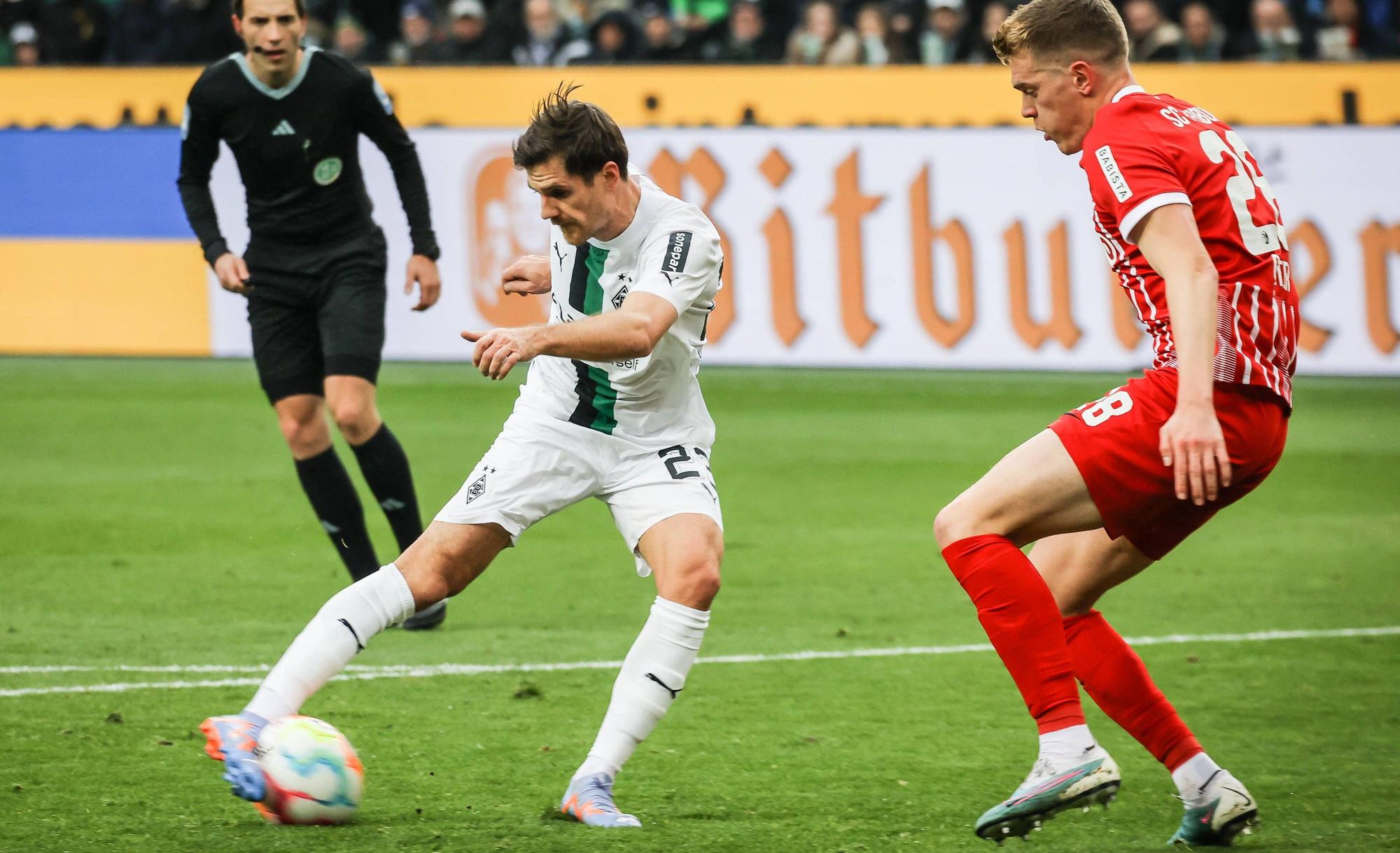 Gladbach-Star Jonas Hofmann (l.) im Zweikampf mit Matthias Ginter (r.) vom SC Freiburg während der Bundesliga-Partie am Samstag (4. März 2023) im Borussia-Park. Hofmann schießt mit rechts.
