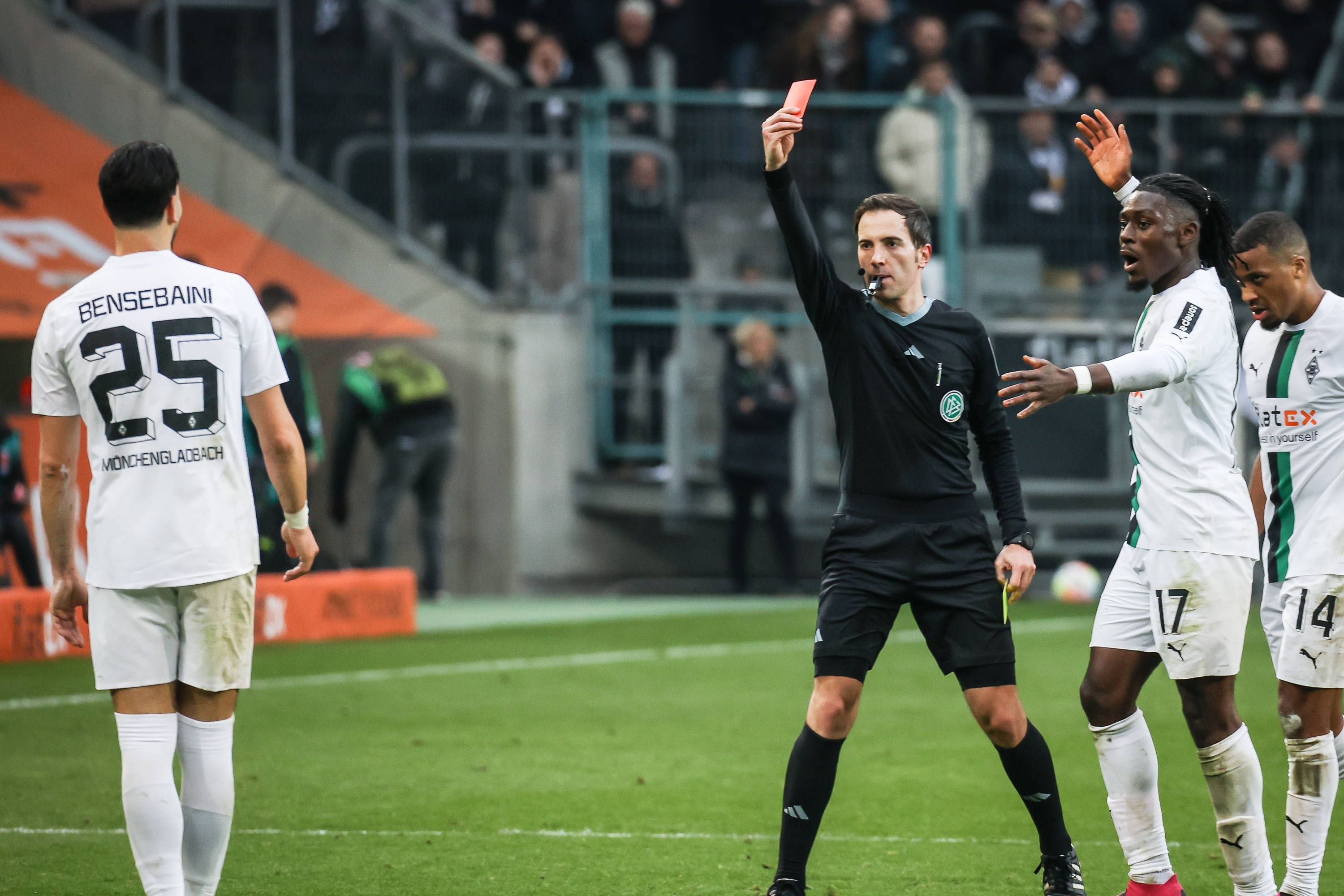 Benjamin Brand (Mitte) zeigte Gladbach-Profi Ramy Bensebaini (l.) am Samstag (4. März 2023) in der Schlussphase der Partie gegen den SC Freiburg die Gelb-Rote Karte. Der Algerier reagierte mit verbalen Entgleisungen auf die Entscheidung.