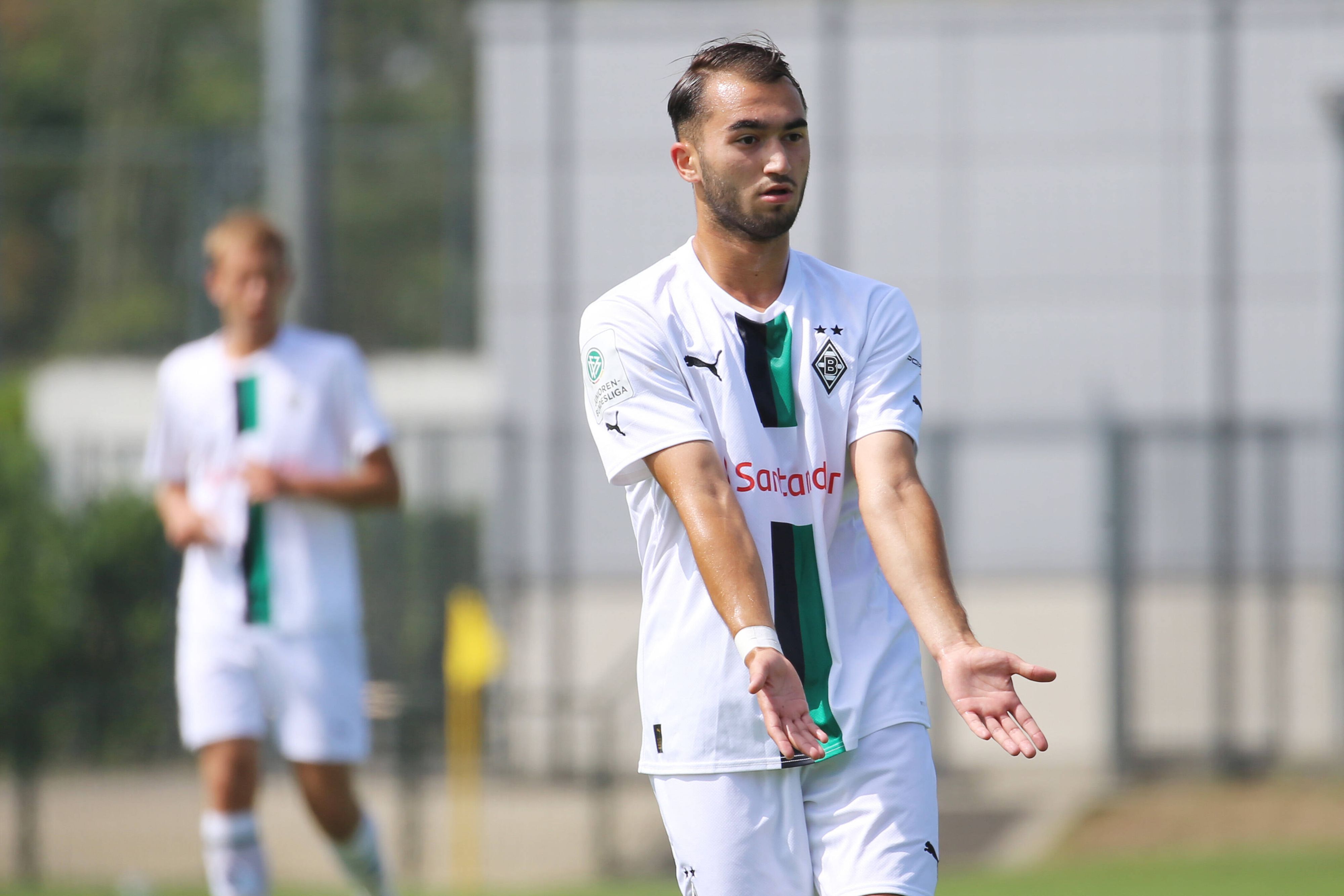 Daniel Aserov, Spieler der U17 von Borussia Mönchengladbach, hier am 20. August 2022 beim B-Junioren-Bundesligaspiel gegen Preußen Münster. Aserov hat beide Hände nach flach nach vorne ausgebreitet und zeigt an, angespielt werden zu wollen.