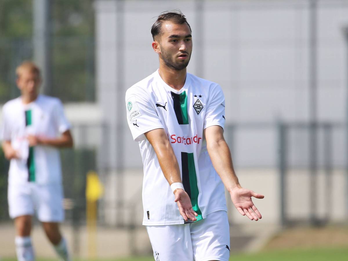 Daniel Aserov, Spieler der U17 von Borussia Mönchengladbach, hier am 20. August 2022 beim B-Junioren-Bundesligaspiel gegen Preußen Münster. Aserov hat beide Hände nach flach nach vorne ausgebreitet und zeigt an, angespielt werden zu wollen.
