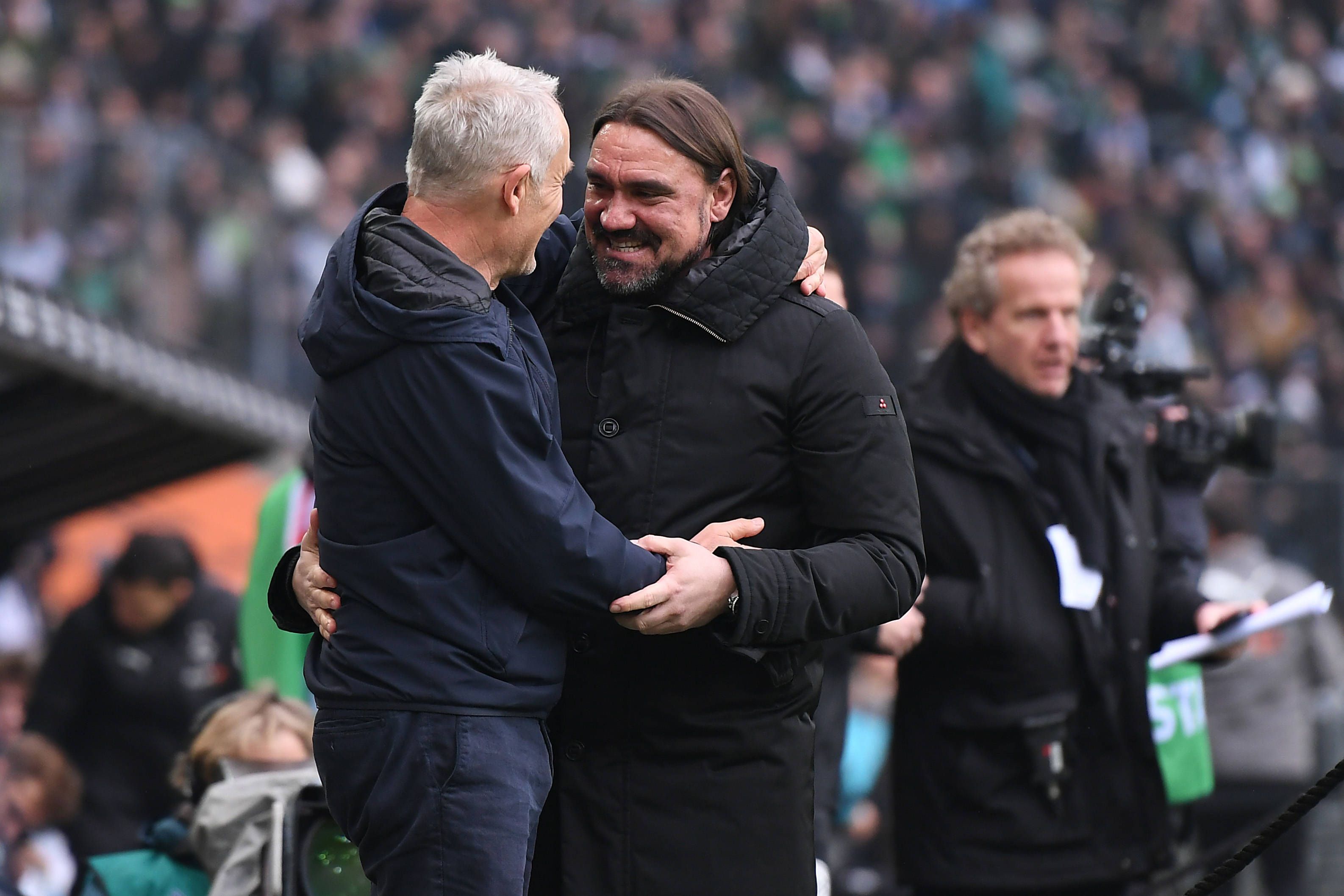 Christian Streich, Trainer vom SC Freiburg (l.), und Daniel Farke, Trainer von Borussia Mönchengladbach, begrüßen sich vor dem Bundesliga-Duell ihrer beiden Teams am 4. März 2023 im Borussia-Park. Farke und Streich umarmen sich und lächeln.