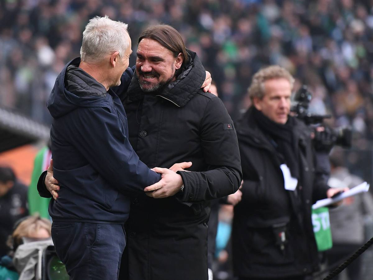 Christian Streich, Trainer vom SC Freiburg (l.), und Daniel Farke, Trainer von Borussia Mönchengladbach, begrüßen sich vor dem Bundesliga-Duell ihrer beiden Teams am 4. März 2023 im Borussia-Park. Farke und Streich umarmen sich und lächeln.