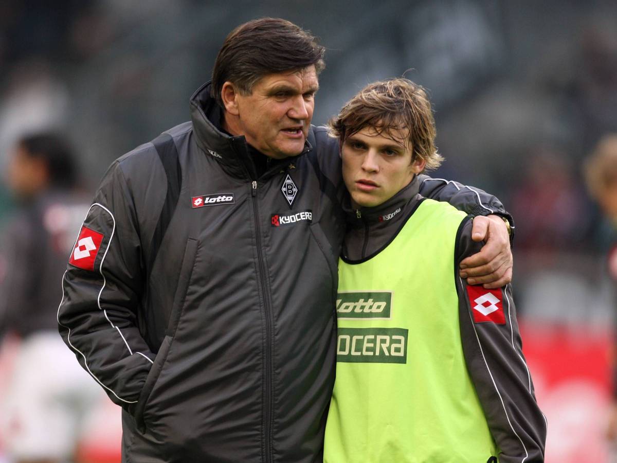 Trainer Hans Meyer (l.) spricht vor dem Bundesliga-Spiel von Borussia Mönchengladbach gegen Bayer Leverkusen am 6. Dezember 2008 mit Startelf-Debütant Tony Jantschke. Der Trainer legt beim Aufwärmen im Borussia-Park seinen Arm um den Teenager.