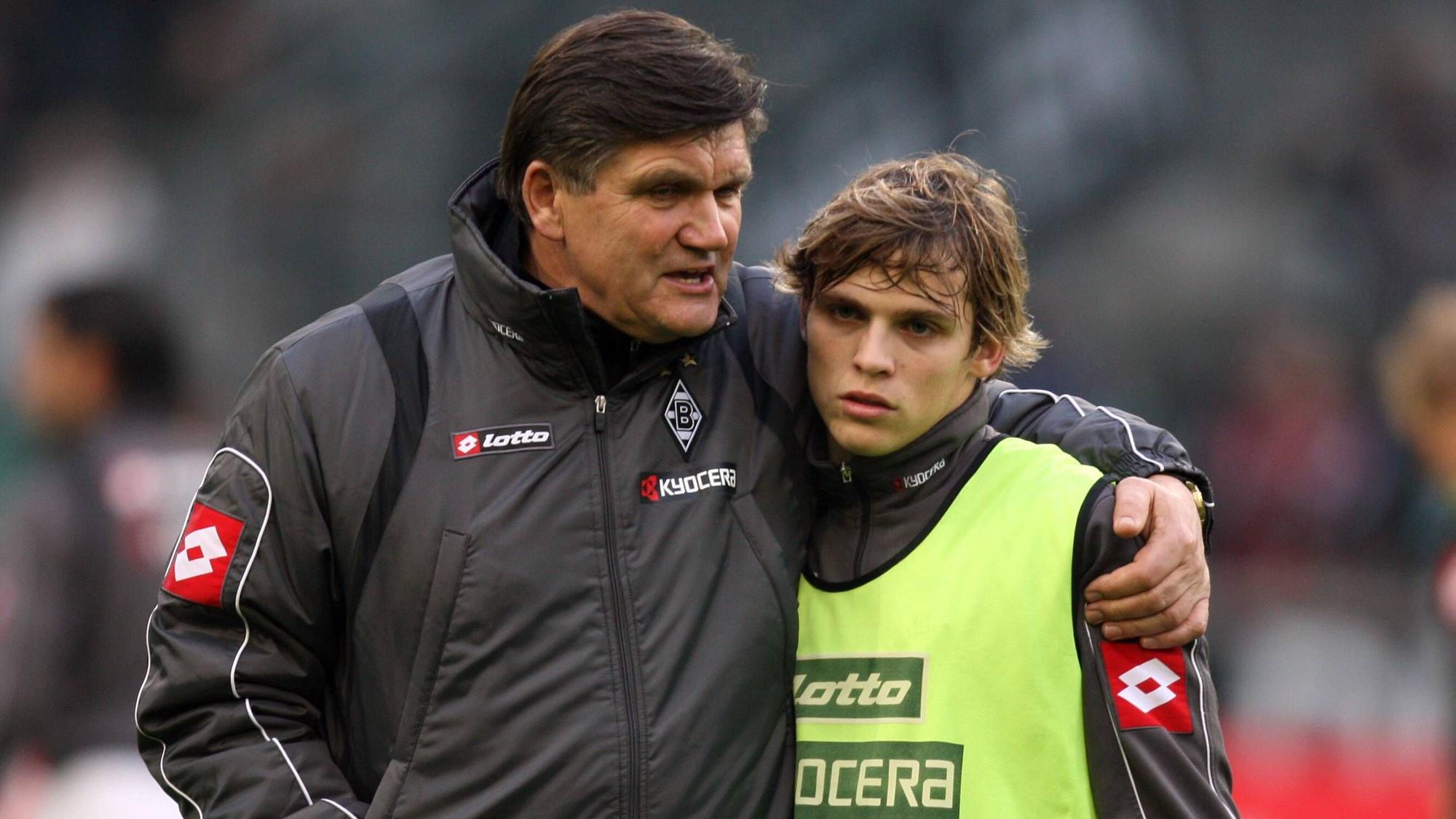 Trainer Hans Meyer (l.) spricht vor dem Bundesliga-Spiel von Borussia Mönchengladbach gegen Bayer Leverkusen am 6. Dezember 2008 mit Startelf-Debütant Tony Jantschke. Der Trainer legt beim Aufwärmen im Borussia-Park seinen Arm um den Teenager.
