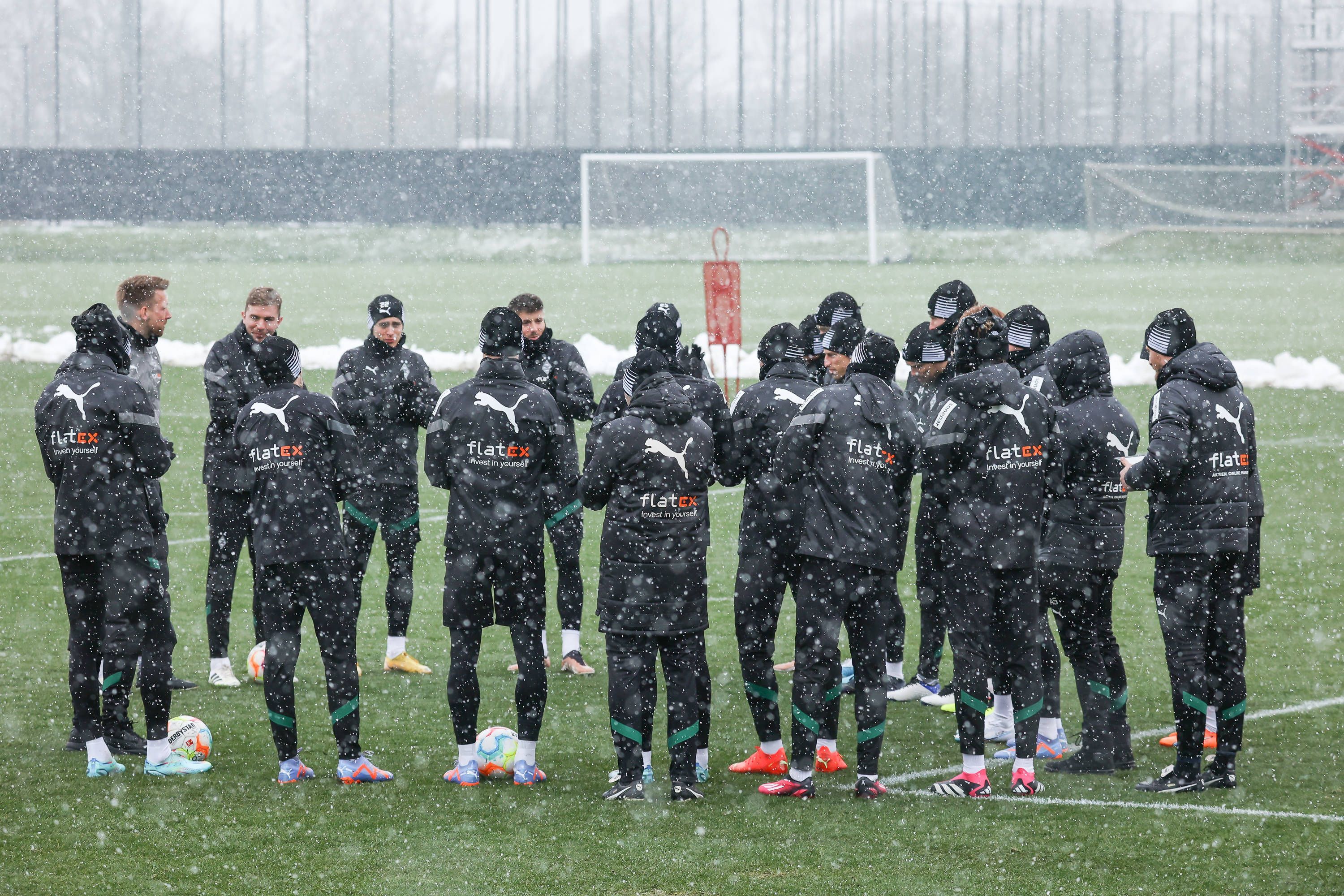 Die Mannschaft von Borussia Mönchengladbach bildet vor dem Training am 20. Januar 2023 bei dichtem Schneefall einen Kreis.