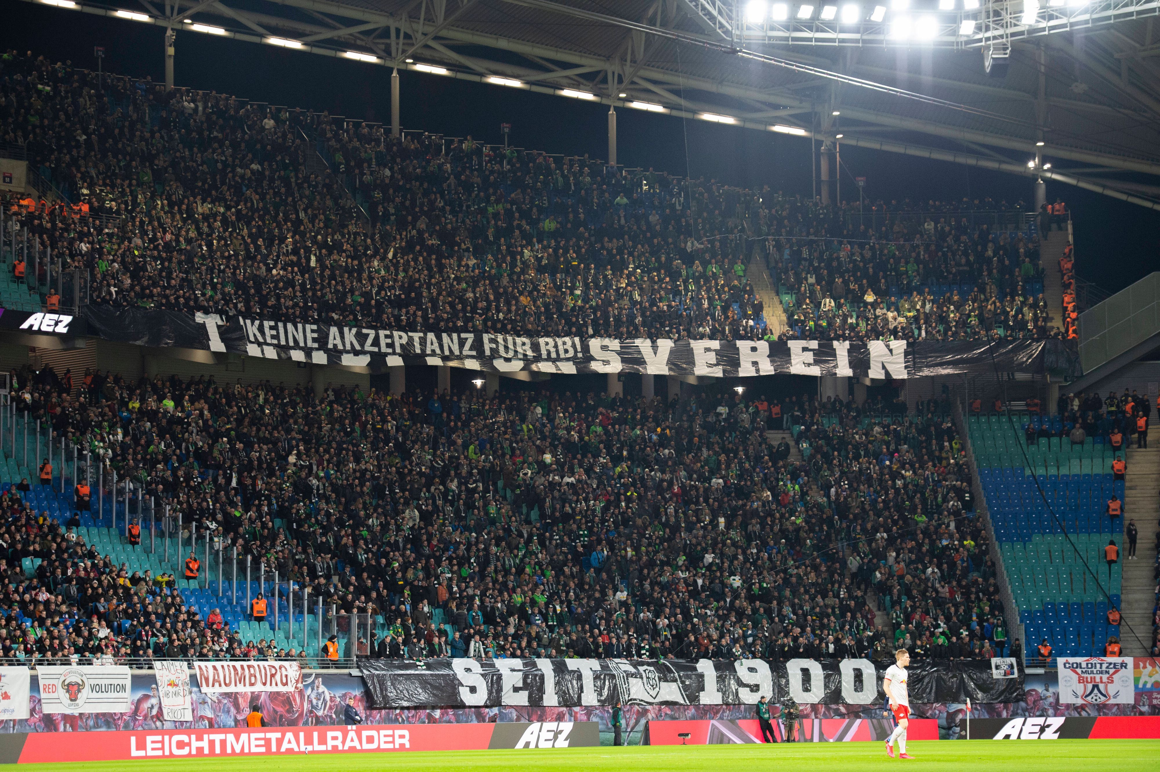 Gladbach-Fans im Gäste-Block der Leipziger Arena bringen ihren Standpunkt zu RB Leipzig zum Ausdruck. Dieses Foto stammt vom 1. Februar 2020. Zu sehen sind riesiger Banner mit Aufschriften.