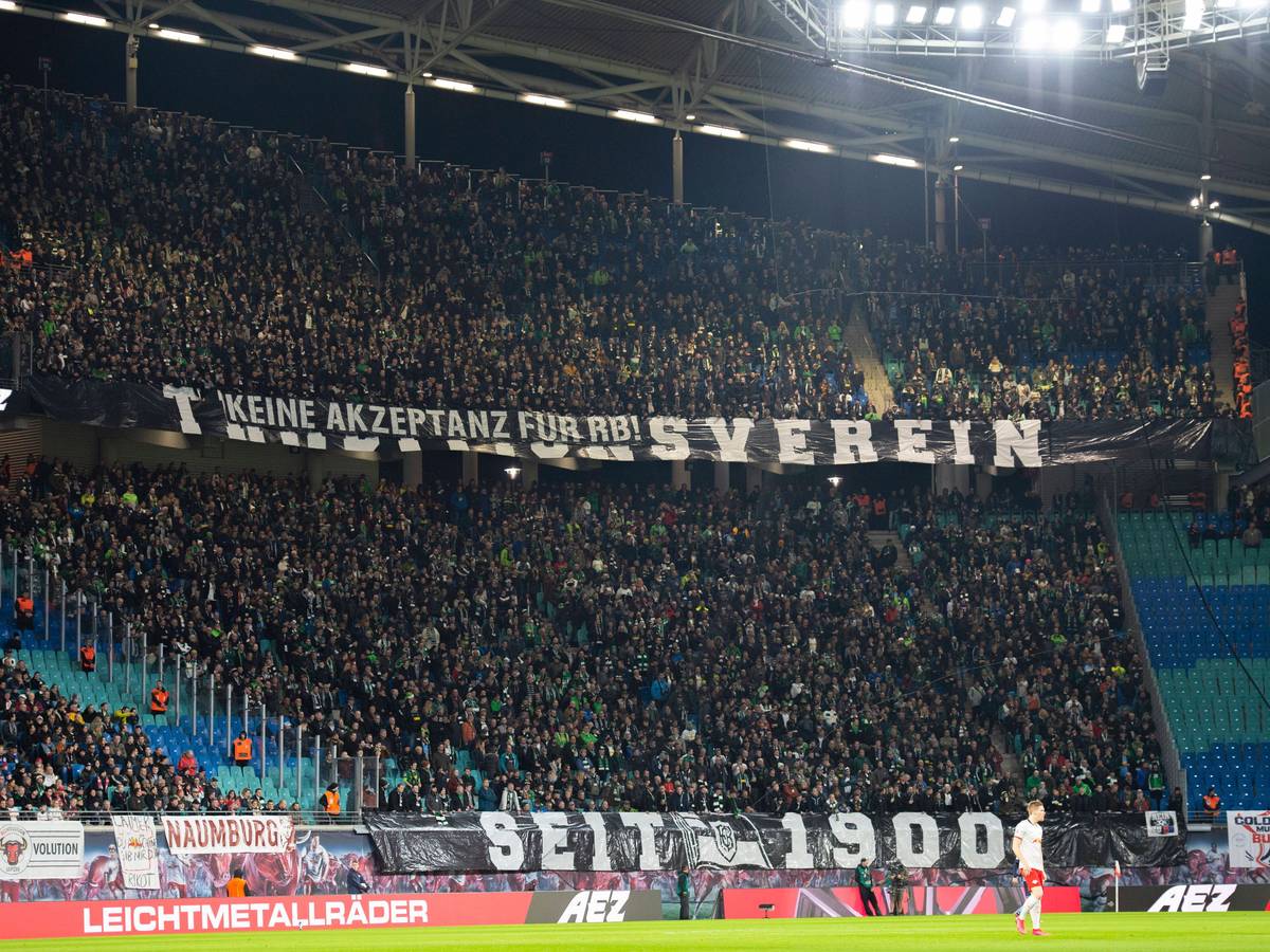 Gladbach-Fans im Gäste-Block der Leipziger Arena bringen ihren Standpunkt zu RB Leipzig zum Ausdruck. Dieses Foto stammt vom 1. Februar 2020. Zu sehen sind riesiger Banner mit Aufschriften.