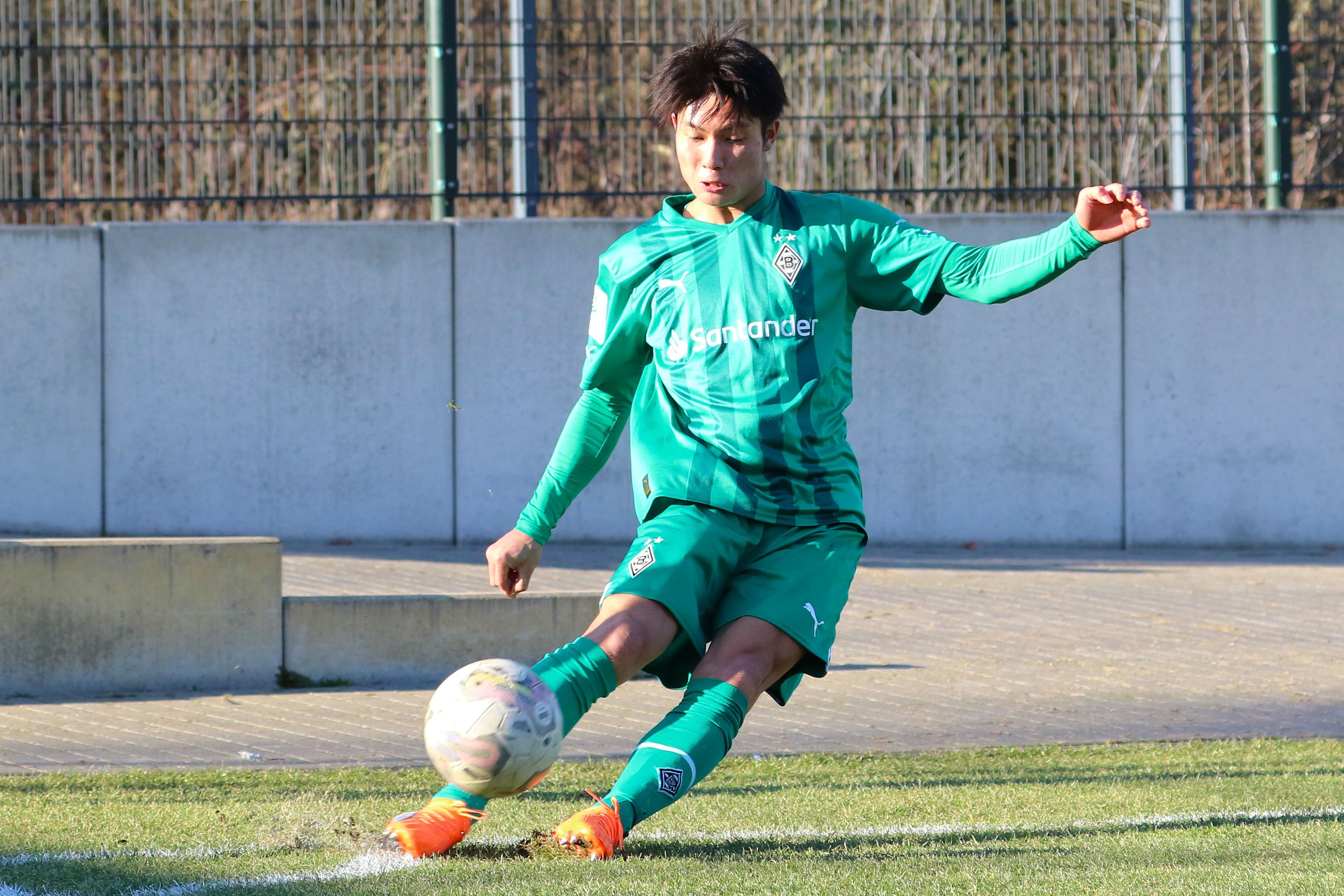 Shio Fukuda, hier am 14. Februar 2023, läuft seit Anfang Februar 2023 für Borussia Mönchengladbach auf und kommt aktuell für die U19 zum Einsatz. Auf dem Foto tritt der Angreifer aus Japan eine Ecke im  grünen Auswärts-Trikot von Gladbach.