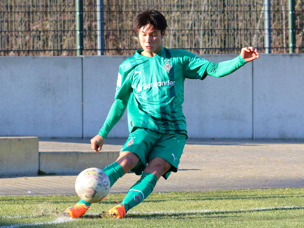 Shio Fukuda, hier am 14. Februar 2023, läuft seit Anfang Februar 2023 für Borussia Mönchengladbach auf und kommt aktuell für die U19 zum Einsatz. Auf dem Foto tritt der Angreifer aus Japan eine Ecke im grünen Auswärts-Trikot von Gladbach.