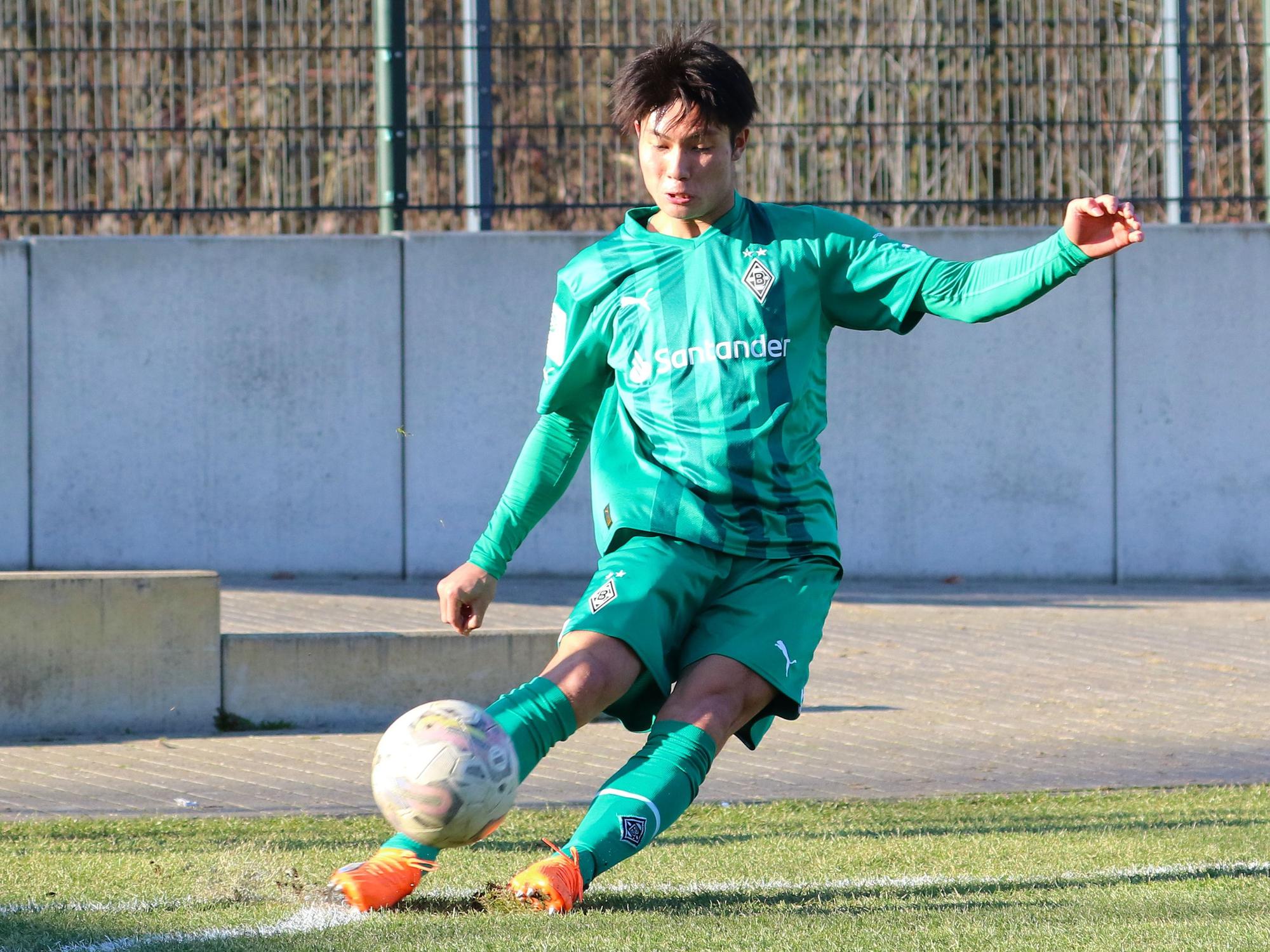 Shio Fukuda, hier am 14. Februar 2023, läuft seit Anfang Februar 2023 für Borussia Mönchengladbach auf und kommt aktuell für die U19 zum Einsatz. Auf dem Foto tritt der Angreifer aus Japan eine Ecke im grünen Auswärts-Trikot von Gladbach.