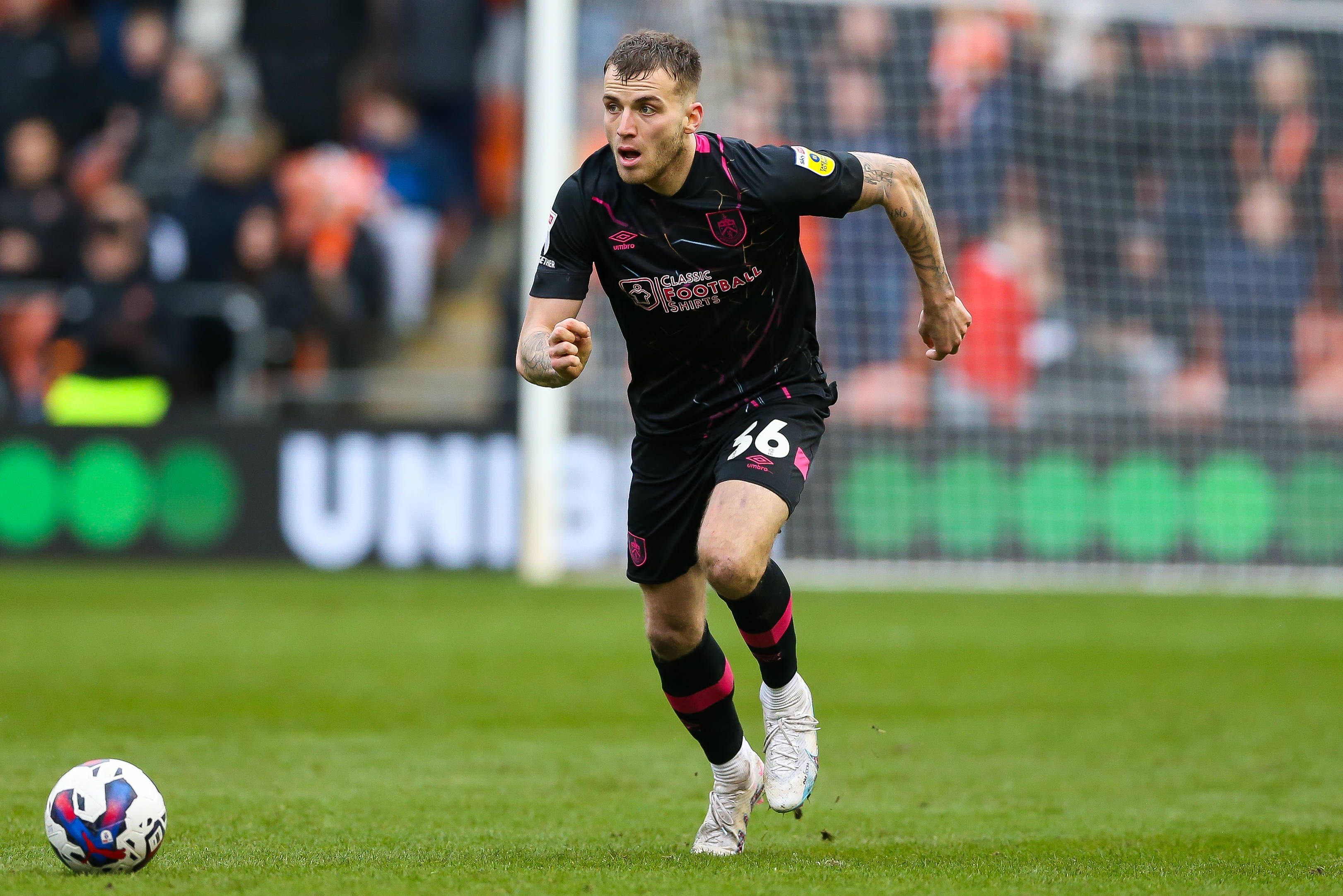 Jordan Beyer, hier am 4. März 2023, läuft im dunklen Auswärtstrikot des FC Burnley mit dem Ball nach vorne. Das Foto zeigt Beyer im Spiel gegen Blackpool in der englischen Championship.