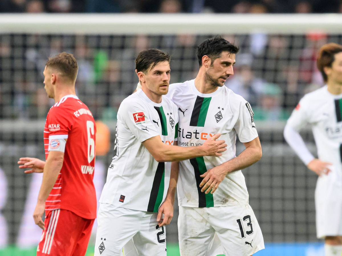 Jonas Hofmann (l.) jubelt nach dem Bundesliga-Sieg von Borussia Mönchengladbach gegen Bayern München am 18. Februar 2023 gemeinsam mit Mitspieler Lars Stindl. Die beiden Gladbach-Spieler liegen sich nach Abpfiff im Borussia-Park in den Armen.