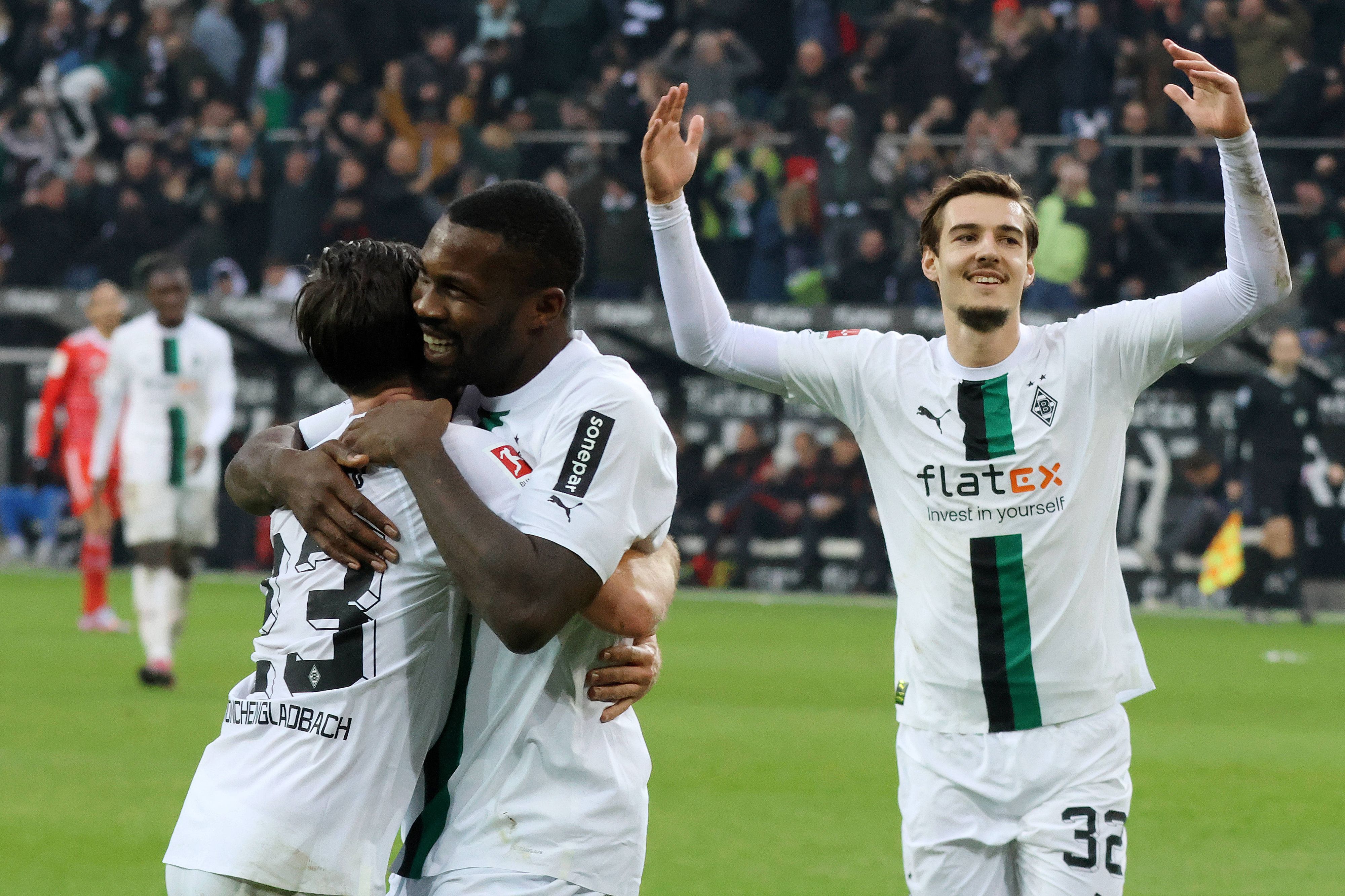 Jonas Hofmann und Marcus Thuram liegen sich nach einem Tor im Bundesliga-Spiel von Borussia Mönchengladbach gegen Bayern München am 18. Februar 2023 in den Armen. Florian Neuhaus feiert mit.