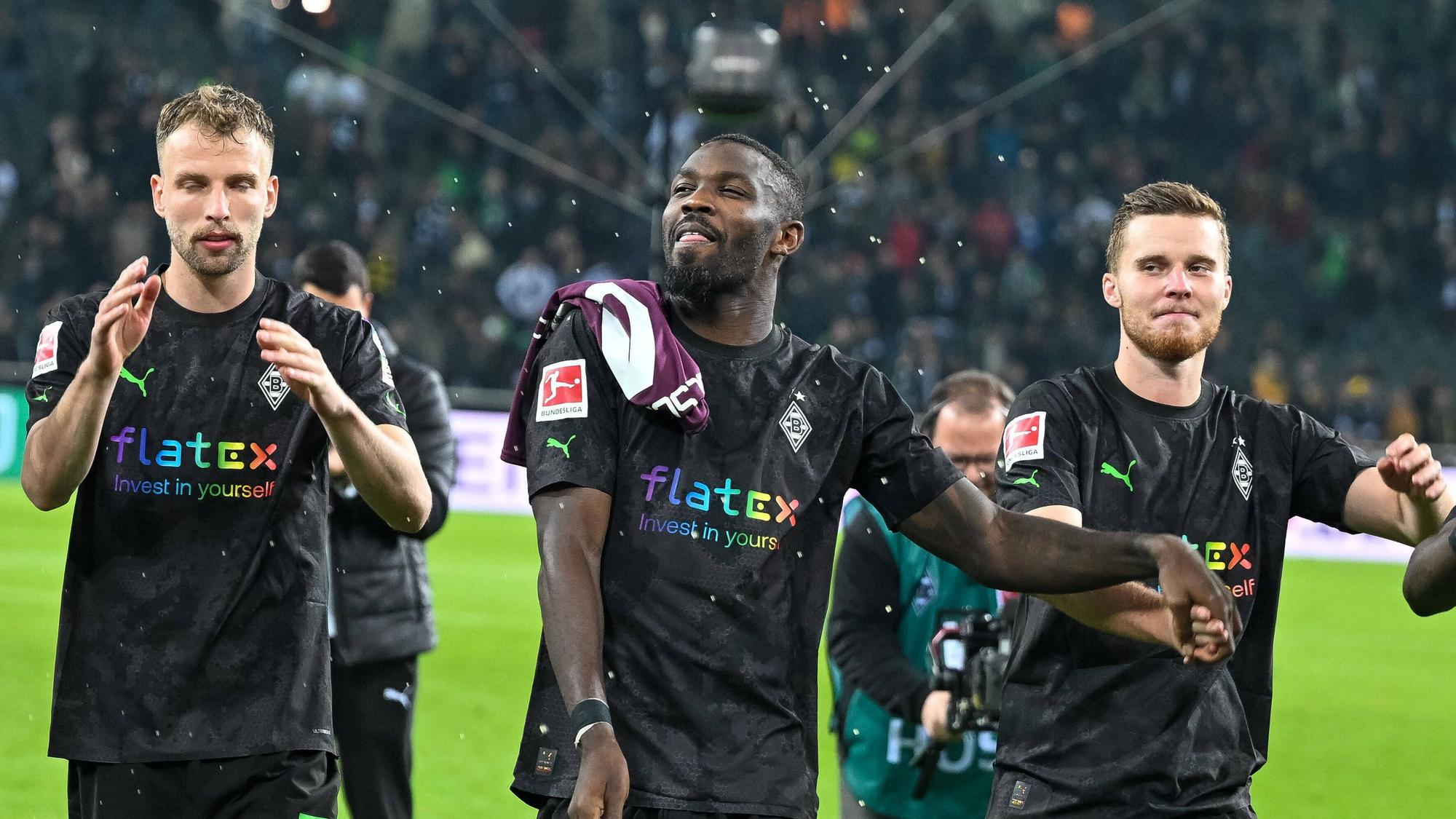 Marcus Thuram (M.) feiert mit Marvin Friedrich (l.) und Nico Elvedi, Thurams Teamkollegen bei Borussia Mönchengladbach, den Bundesliga-Sieg am 11. November 2022 gegen Borussia Dortmund. Seit der WM-Pause läuft es für den Gladbach-Torjäger nicht mehr.