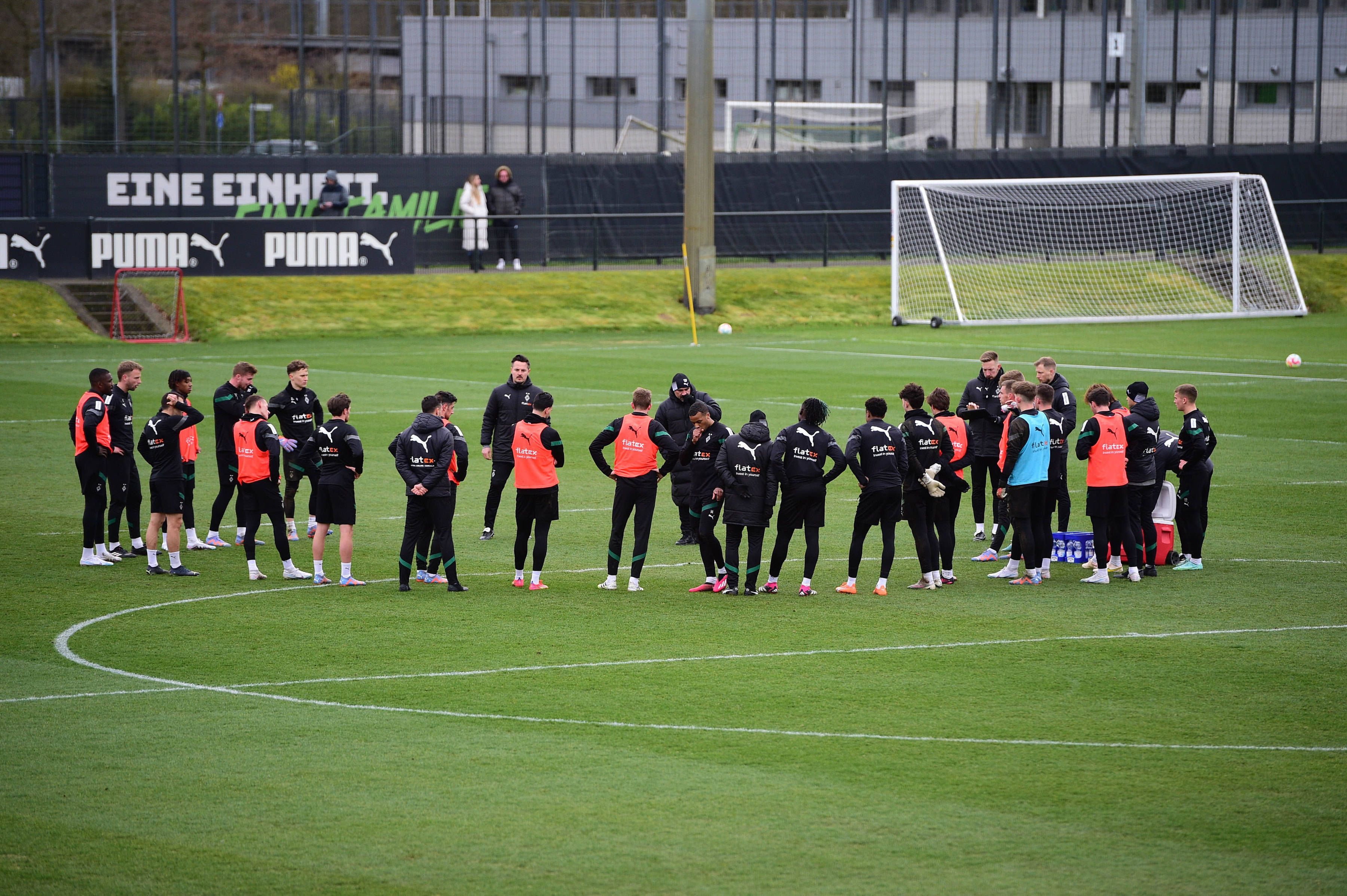 Die Mannschaft von Borussia Mönchengladbach am 14. März 2023 beim Training im Borussia-Park. Das Team steht in einem Kreis zusammen auf dem Rasen.