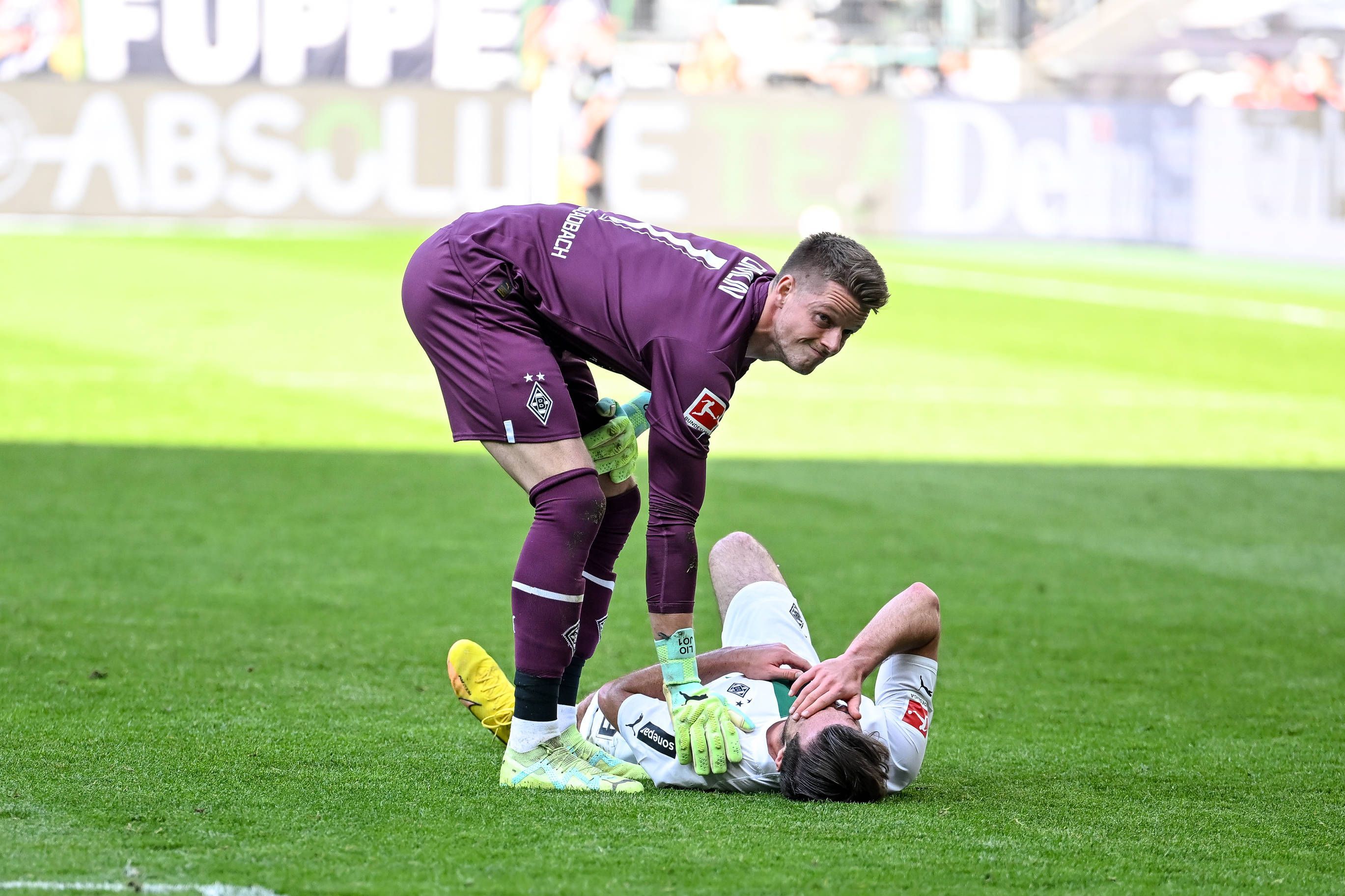Joe Scally liegt im Bundesliga-Spiel von Borussia Mönchengladbach gegen den VfL Wolfsburg am 9. April 2023 am Boden. Jonas Omlin sorgt sich um den Gladbach-Verteidiger.