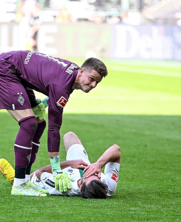 Joe Scally liegt im Bundesliga-Spiel von Borussia Mönchengladbach gegen den VfL Wolfsburg am 9. April 2023 am Boden. Jonas Omlin sorgt sich um den Gladbach-Verteidiger.