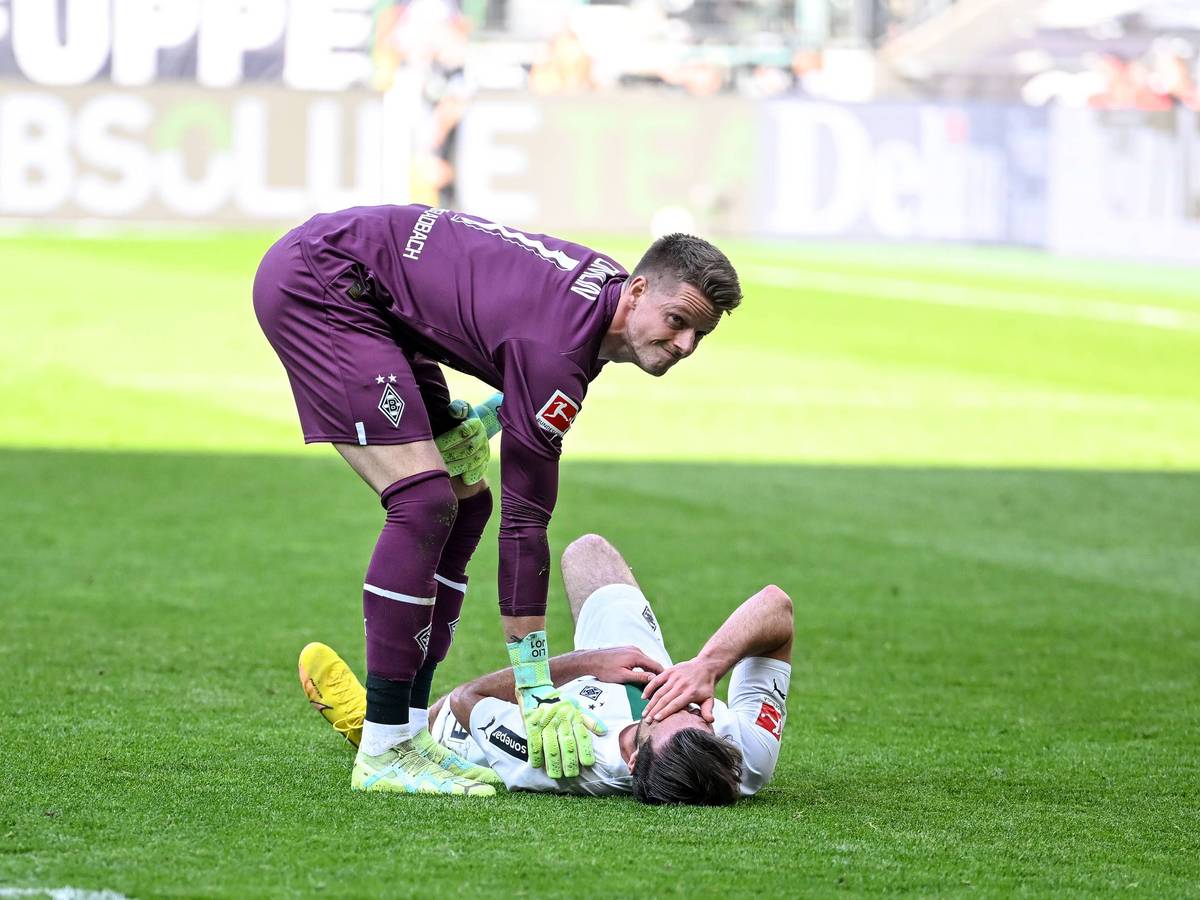 Joe Scally liegt im Bundesliga-Spiel von Borussia Mönchengladbach gegen den VfL Wolfsburg am 9. April 2023 am Boden. Jonas Omlin sorgt sich um den Gladbach-Verteidiger.