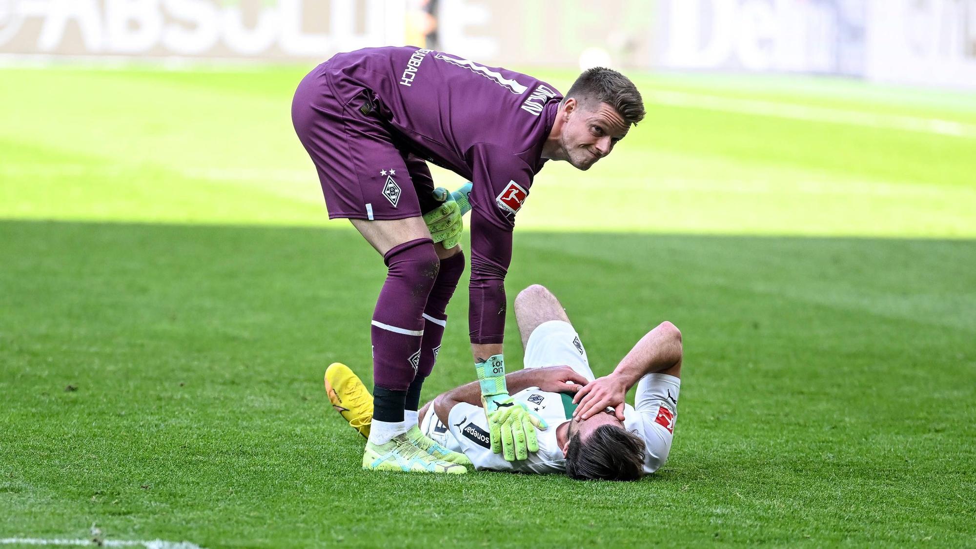 Joe Scally liegt im Bundesliga-Spiel von Borussia Mönchengladbach gegen den VfL Wolfsburg am 9. April 2023 am Boden. Jonas Omlin sorgt sich um den Gladbach-Verteidiger.