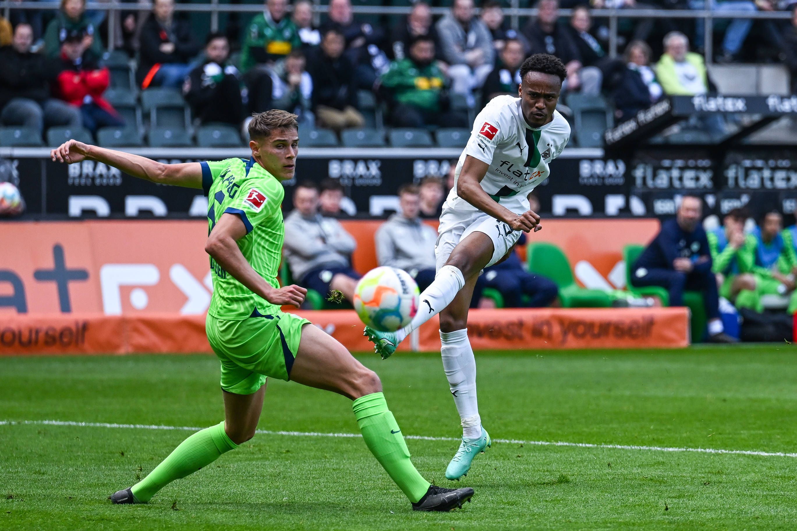 Nathan Ngoumou (r.) schießt sein erstes Tor für Borussia Mönchengladbach. Im Spiel gegen den VfL Wolfsburg am 9. April 2023 setzt er sich gegen Micky van de Ven durch.