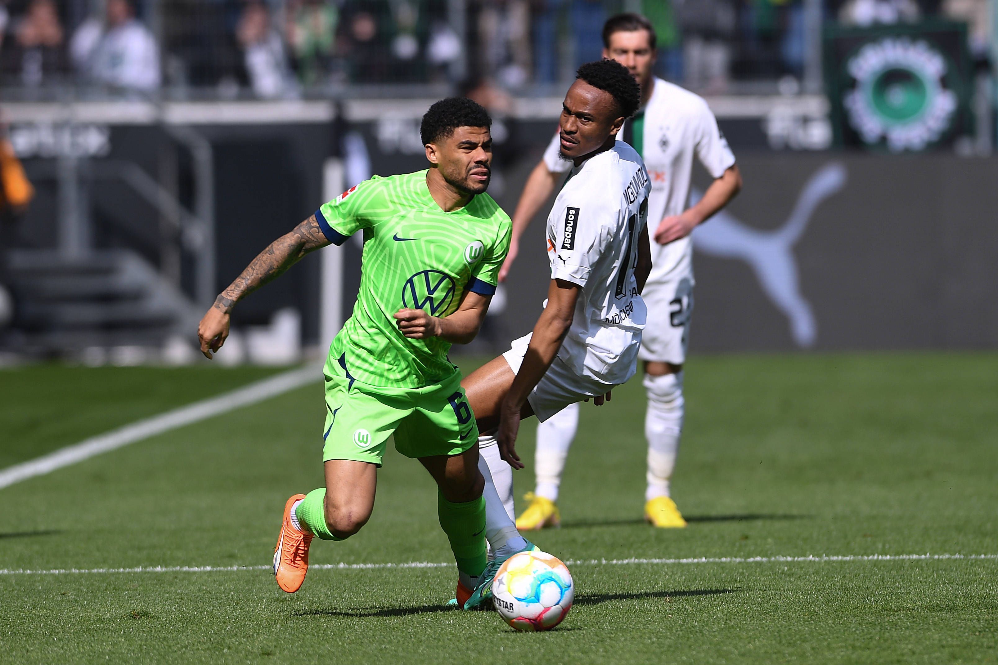 Nathan Ngoumou liefert sich im Spiel von Borussia Mönchengladbach gegen den VfL Wolfsburg am 9. April 2023 einen Zweikampf mit Paulo Otavio (l.).