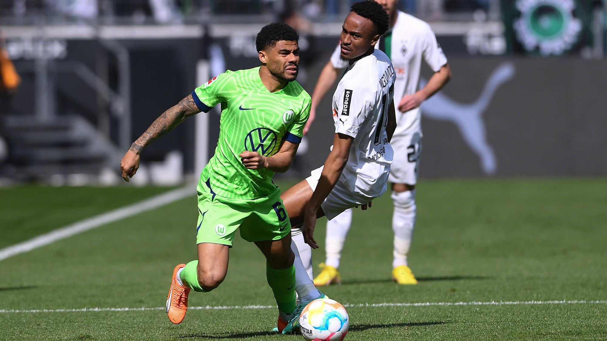 Nathan Ngoumou liefert sich im Spiel von Borussia Mönchengladbach gegen den VfL Wolfsburg am 9. April 2023 einen Zweikampf mit Paulo Otavio (l.).