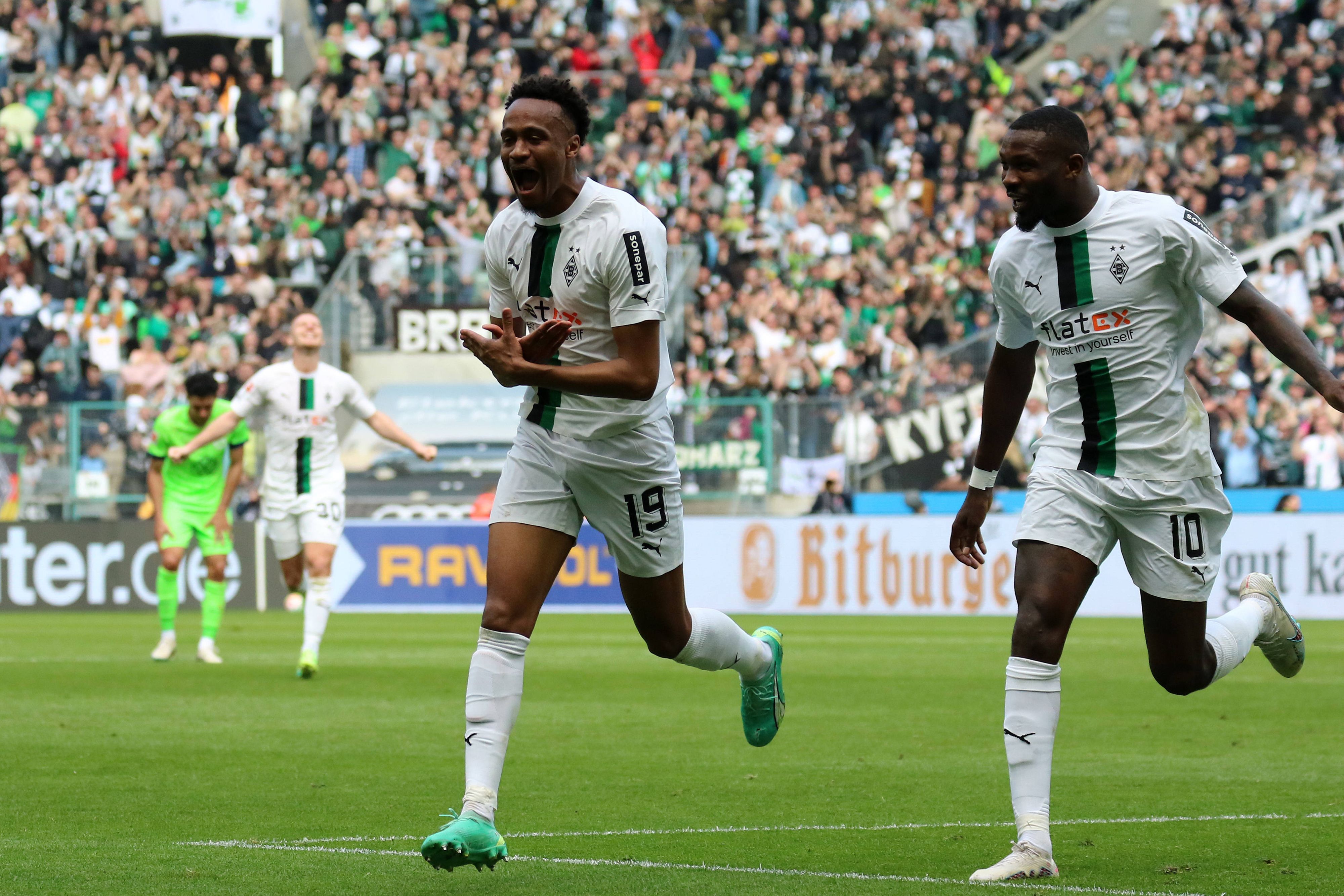 Nathan Ngoumou (l.) bejubelt seinen ersten Bundesliga-Treffer mit Marcus Thuram im Spiel von Borussia Mönchengladbach gegen den VfL Wolfsburg am 9. April 2023.