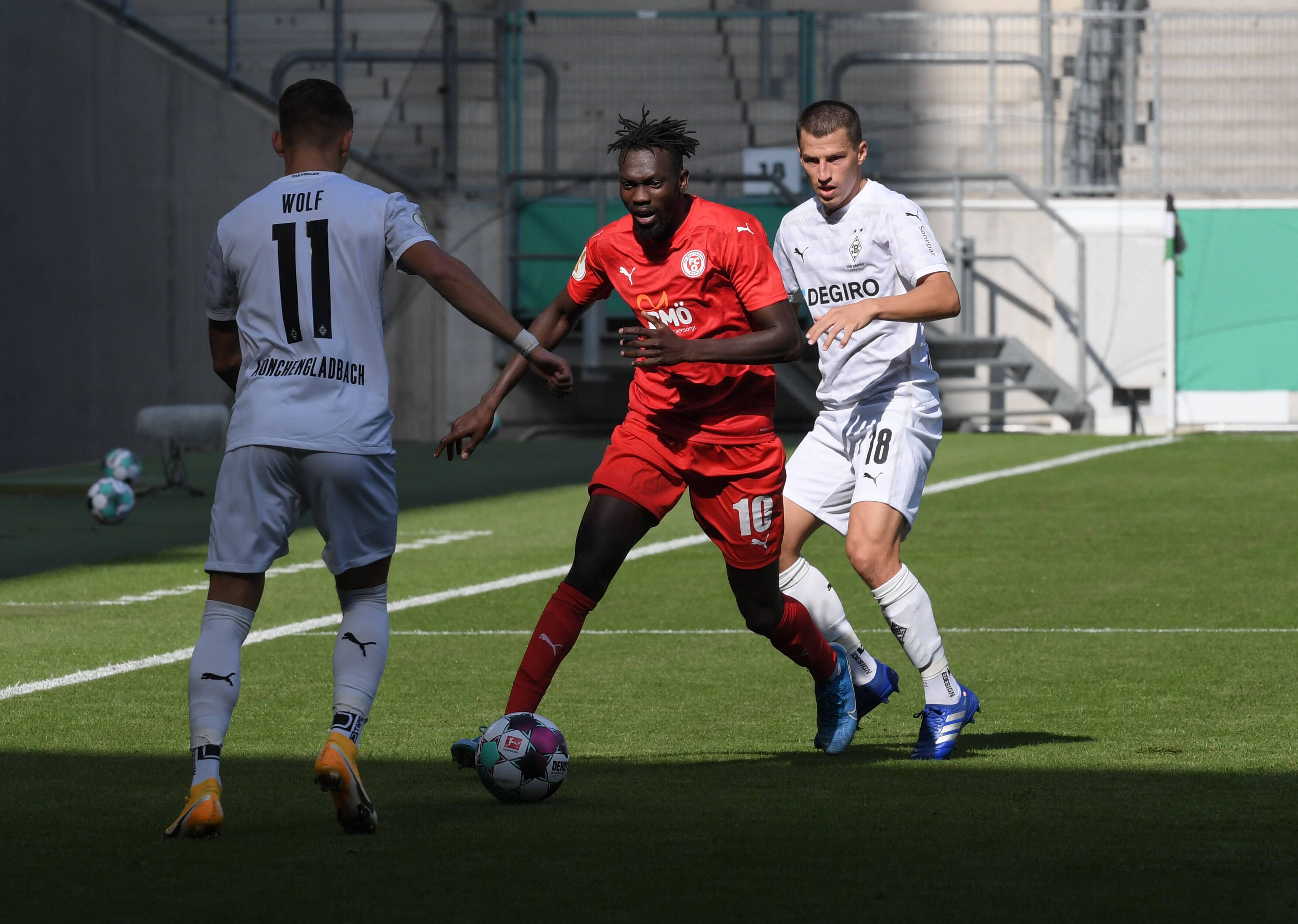 Am 12. September 2020 bestritt Borussia Mönchengladbach das DFB-Pokal-Erstrundenmatch gegen den FC Oberneuland vor leeren Rängen. Das Foto zeigt Stefan Lainer (r.) und Hannes Wolf (l.) im Zweikampft mit Ebrima Jobe (Mitte).