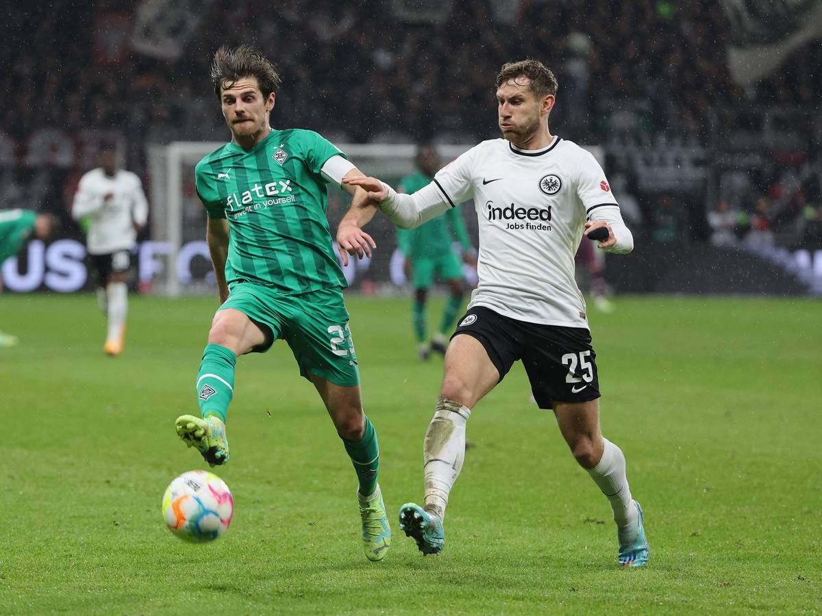 Jonas Hofmann von Borussia Mönchengladbach (l.) am 15. April 2023 im Zweikampf mit Christopher Lenz von Eintracht Frankfurt.